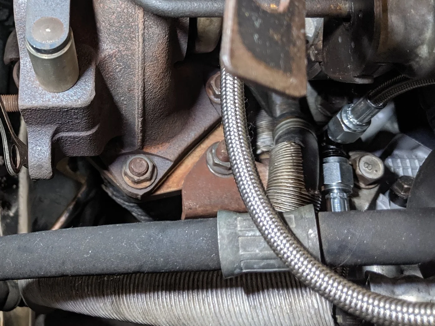 Not easy to photograph given all the spaghetti. But the rusty far right is the bracket and there is one more on the backside of the turbo that hold the turbo and uppipe to the head.