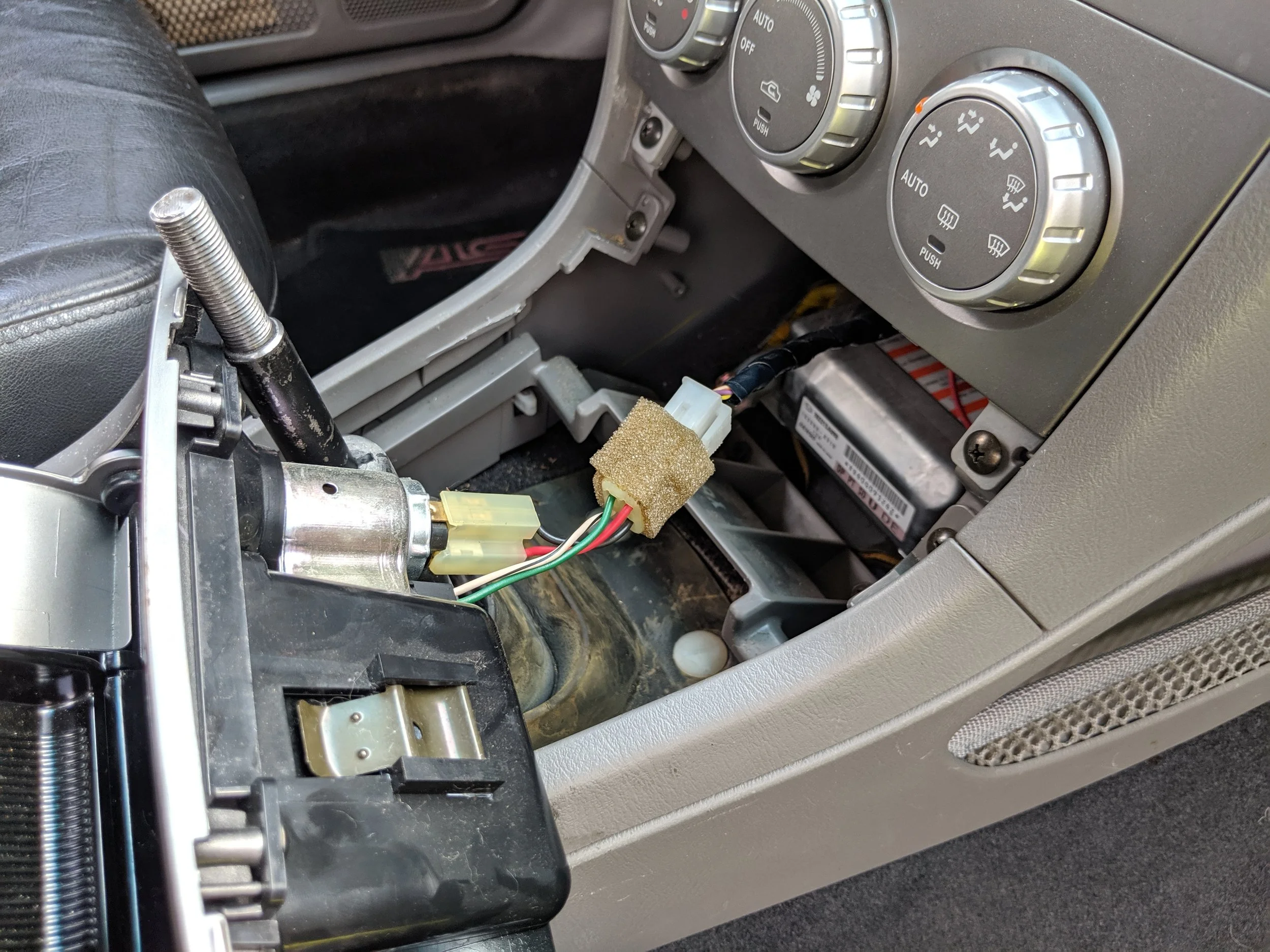 This connection holds the cigarette lighter to the surround. Undoing the clip with the foam coating will allow you to place it aside.