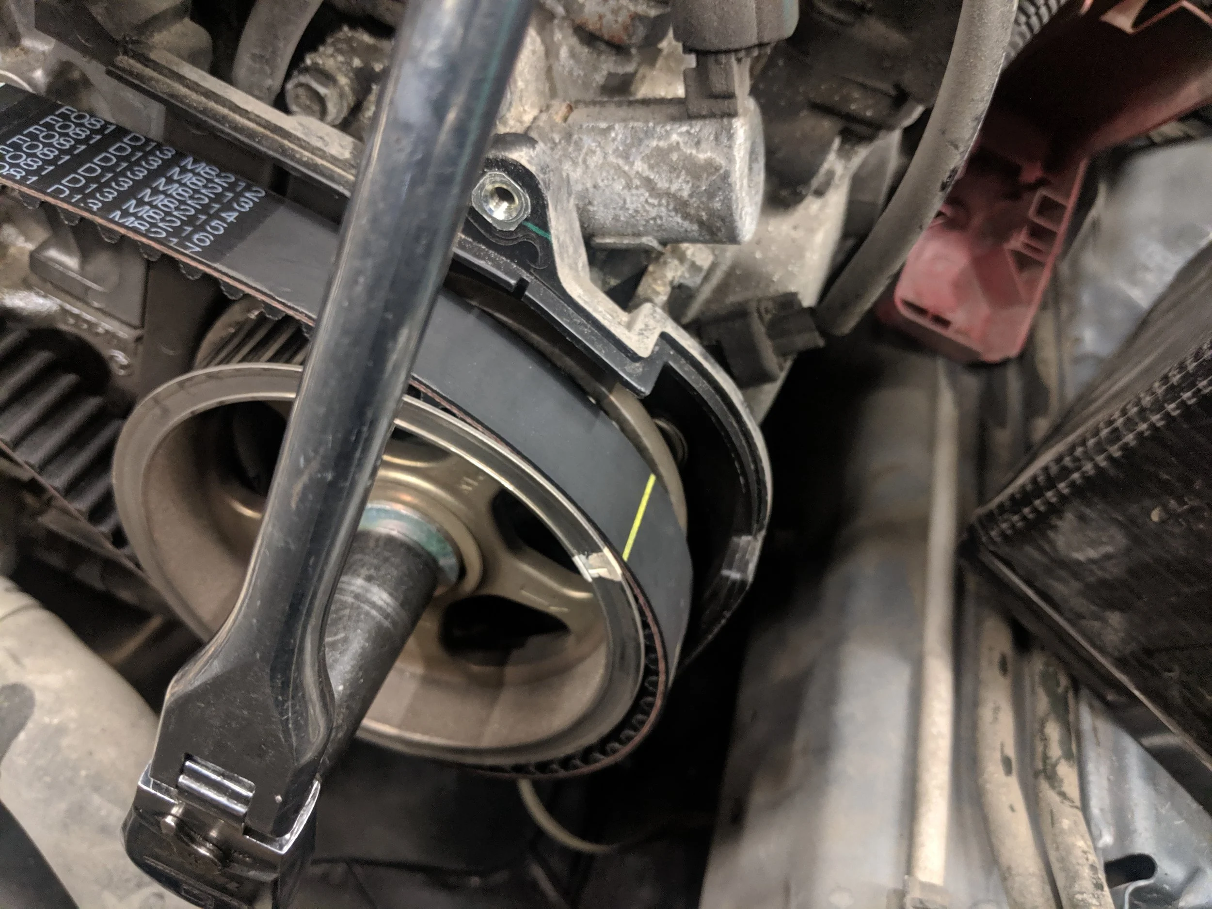 Pulling the cam back into the proper posting with marks lined up. Missing in this image is using the binder clip to hold the belt on while moving the cam.