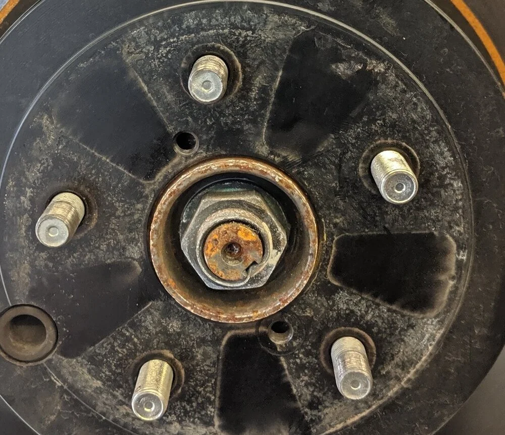 Those bolt holes near the axle nut are threaded, with a bolt ran through them the rotor will pop free. Make sure your parking brake is not engaged, otherwise you are going to have a bad time.