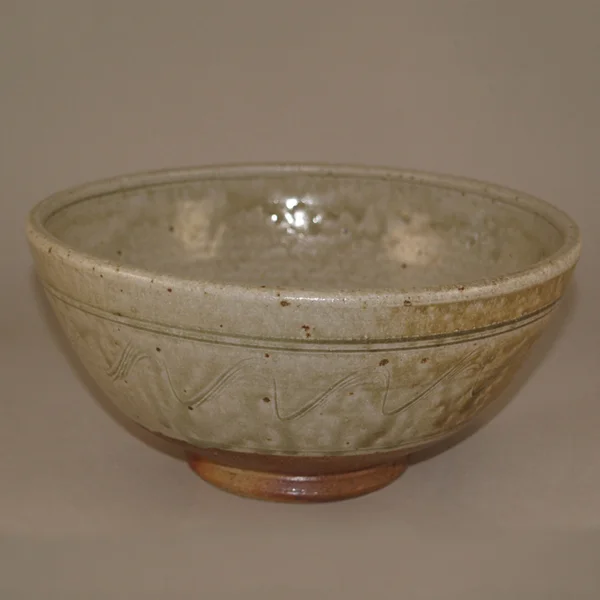 The perfect bowl for your breakfast cereal or soup. Lifted on a turned foot ring this is decorated with an incised wave pattern. The larger size would take a full meal (“The Buddha Bowl”).