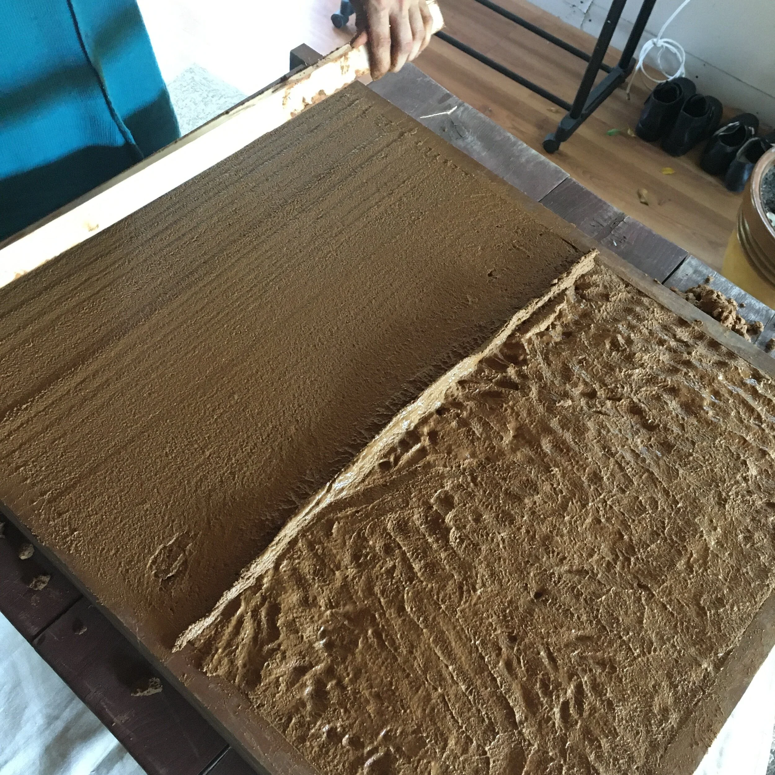  Screeding the mud to create a level surface. 