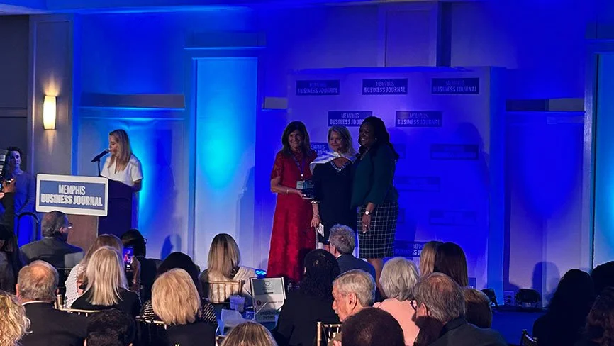 Christi Kelley on stage receiving the Super Women in Business Award from Joanne Massey 2025