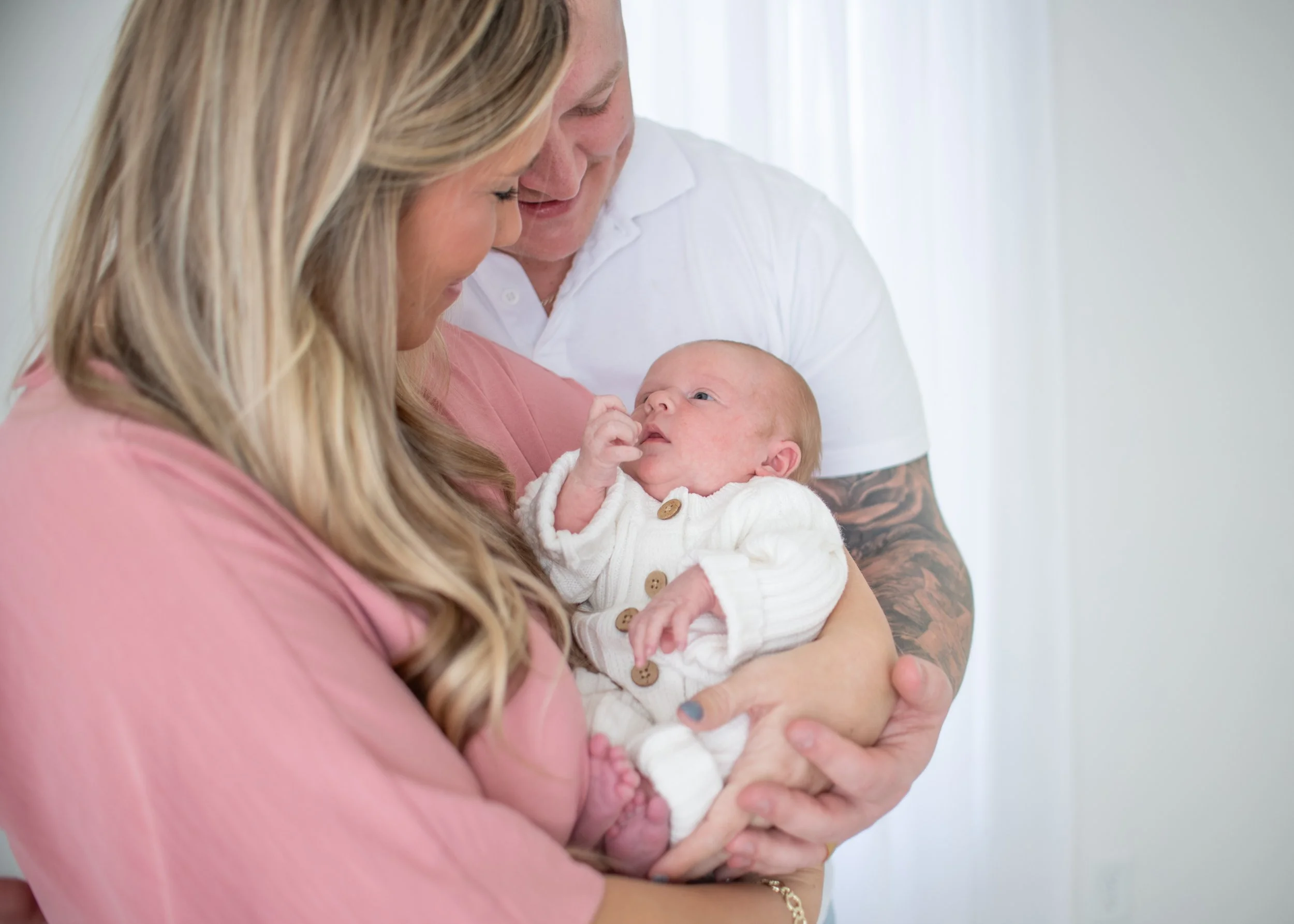 mom and dad holding their newborn baby