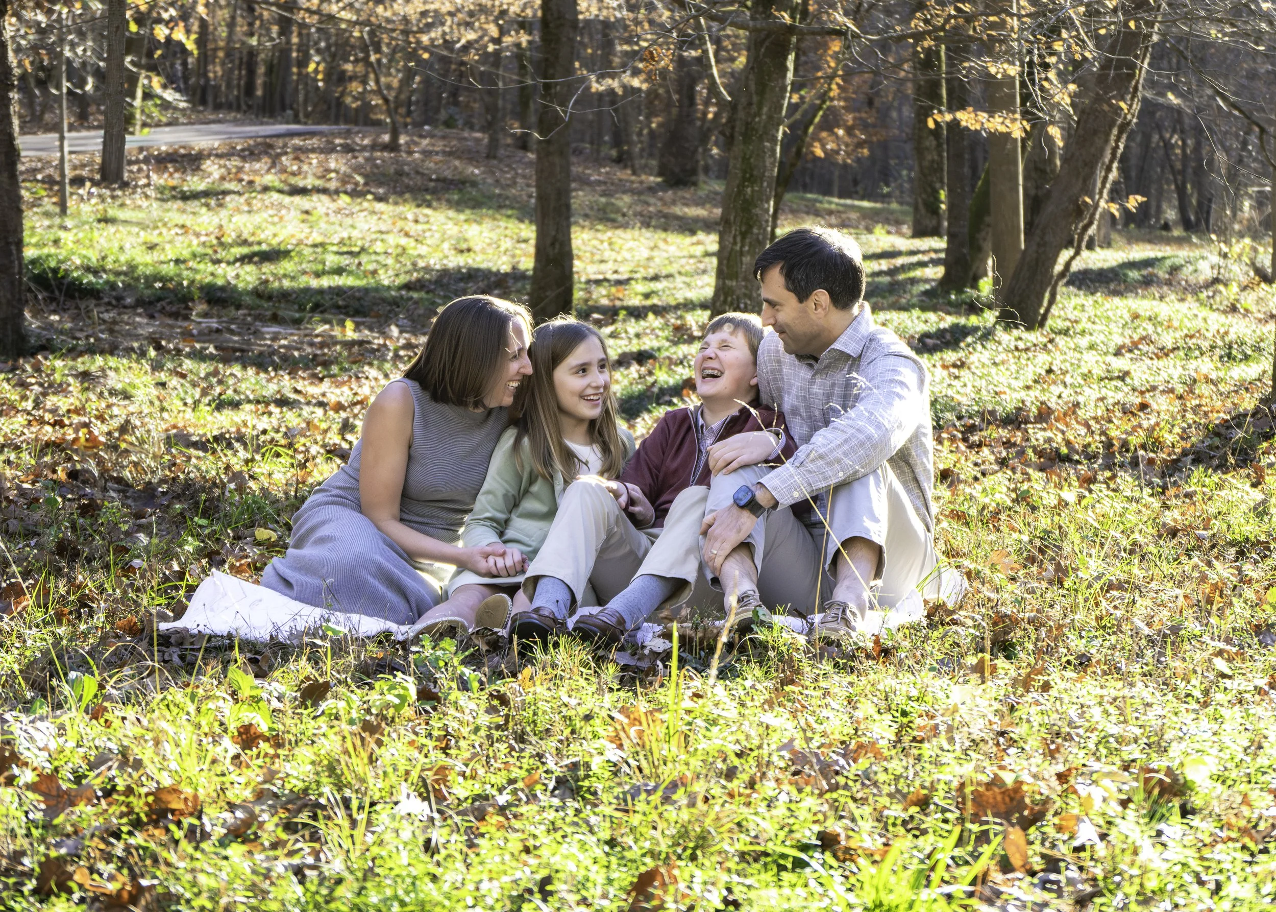 Family of four laughing together during a fall family photo session at Jemison Trail in Mountain Brook.