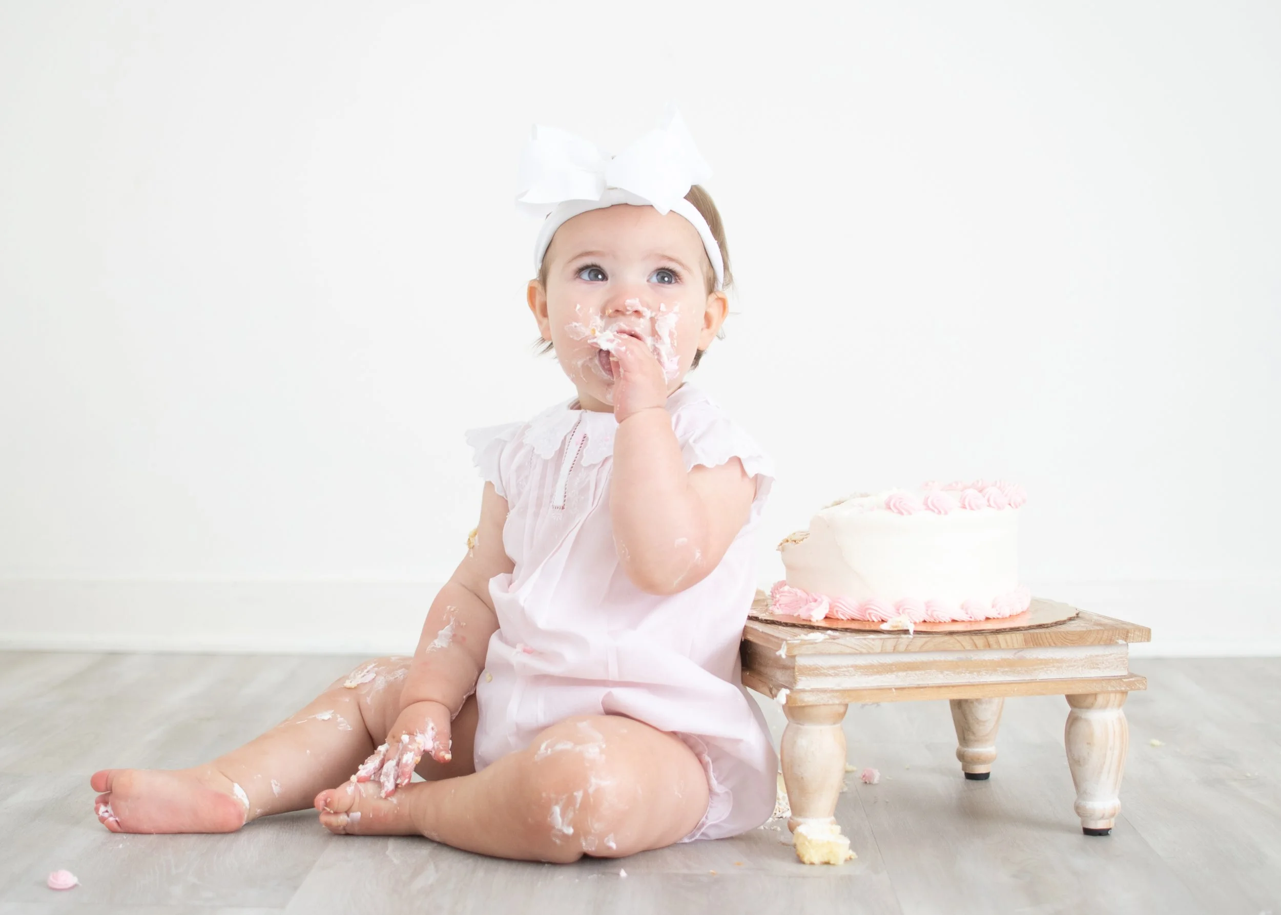 Cake smash photographer Birmingham AL – one-year milestone session with baby and cake in natural light studio.
