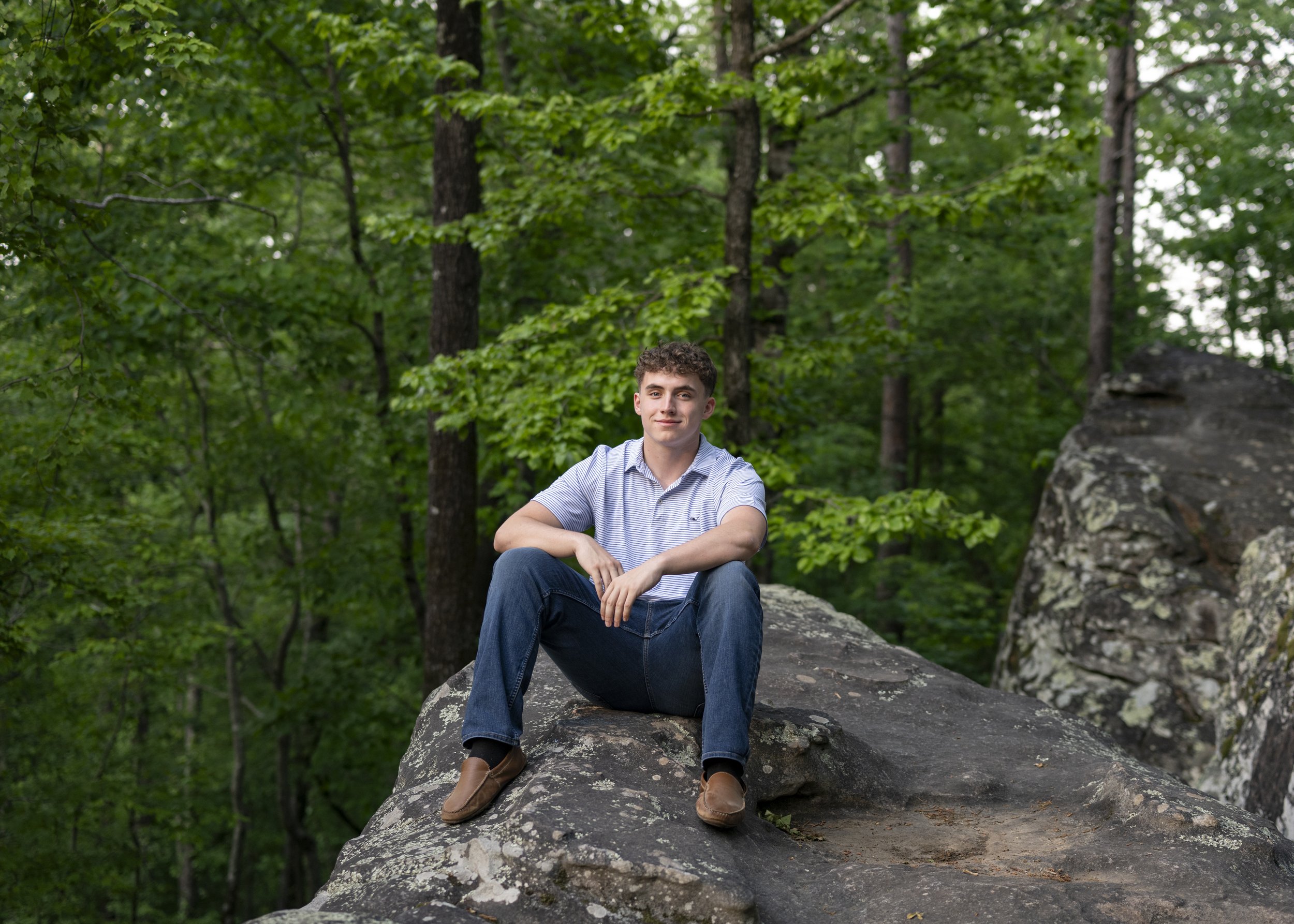 John Carrol Senior Photographer. Senior sitting on a boulder at Moss Rock Preserve