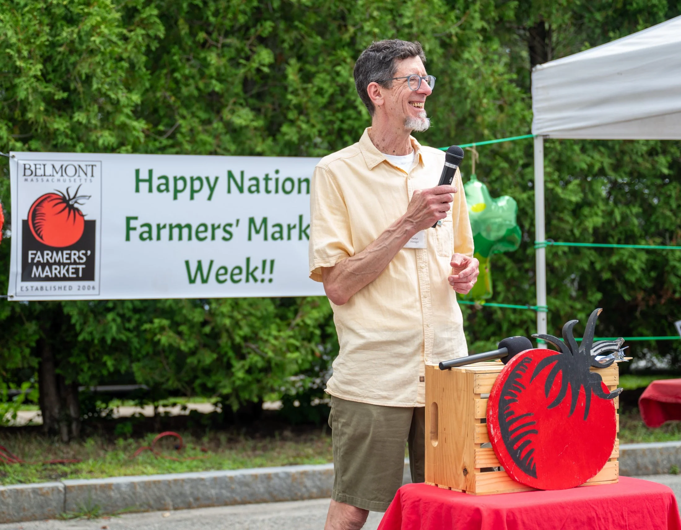 A man in a yellow shirt speaking into a microphone