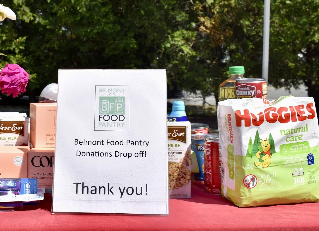 Sign that says "Belmont Food Pantry donations drop off" with items behind it