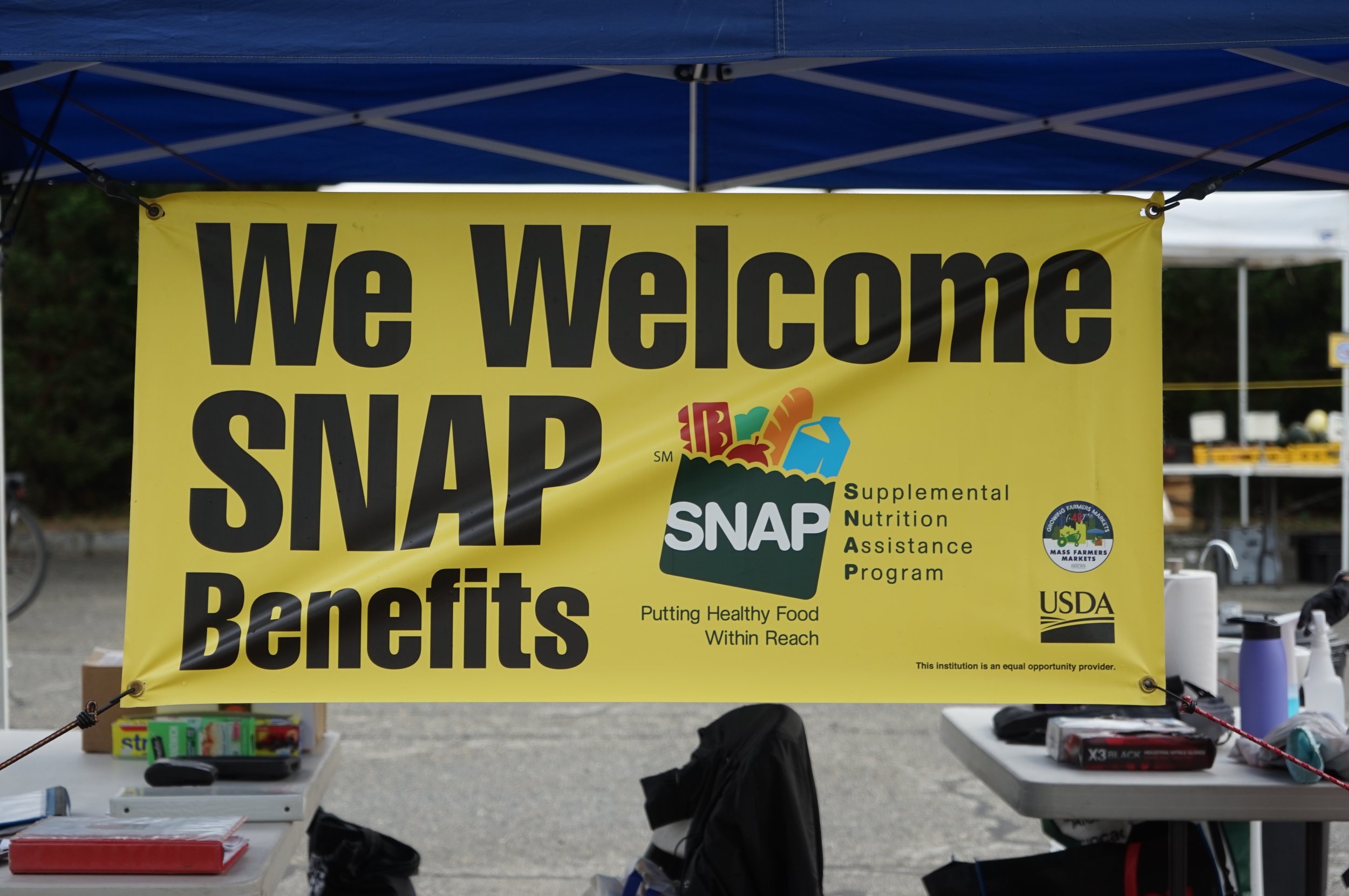A big yellow sign that says "We Welcome SNAP Benefits" with the SNAP logo.