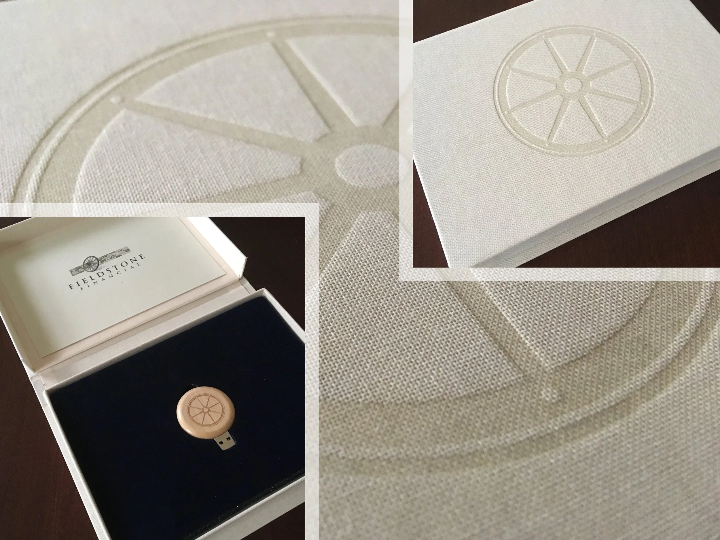 A white box containing a beige round USB flash drive with an embossed wheel design, displayed on a black velvet surface inside the box. The box lid has the logo and text 'Fieldstone Financial' with a wheel graphic.