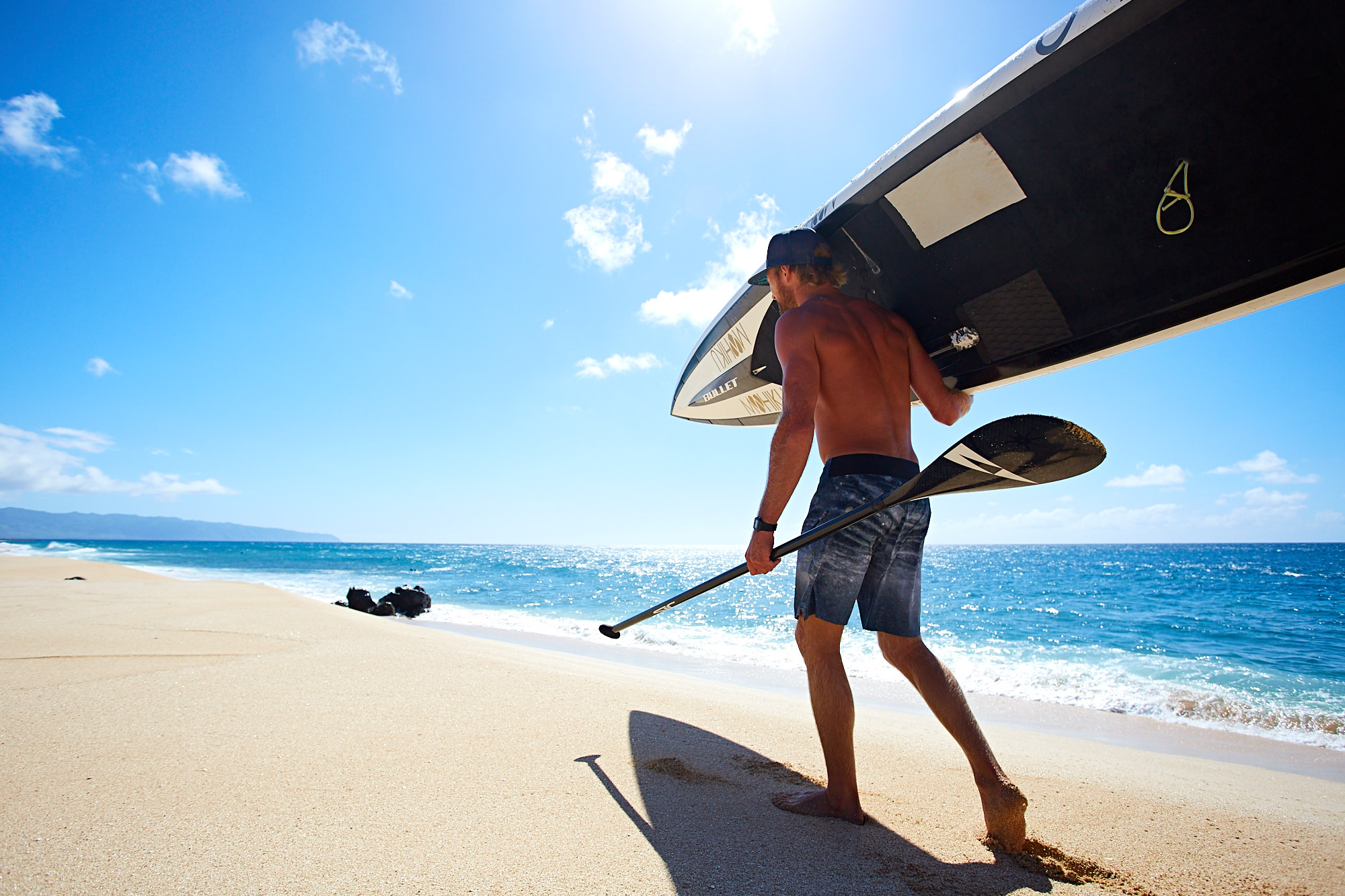 A former Molokai to Oahu paddle Champion Andrew Logreco heads out for a downwind paddle on a summer day in Haleiwa, Hawaii.