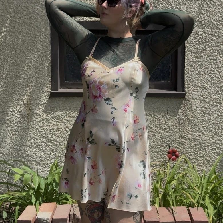 yellow floral opaque slip dress shown layered over a green mesh shirt