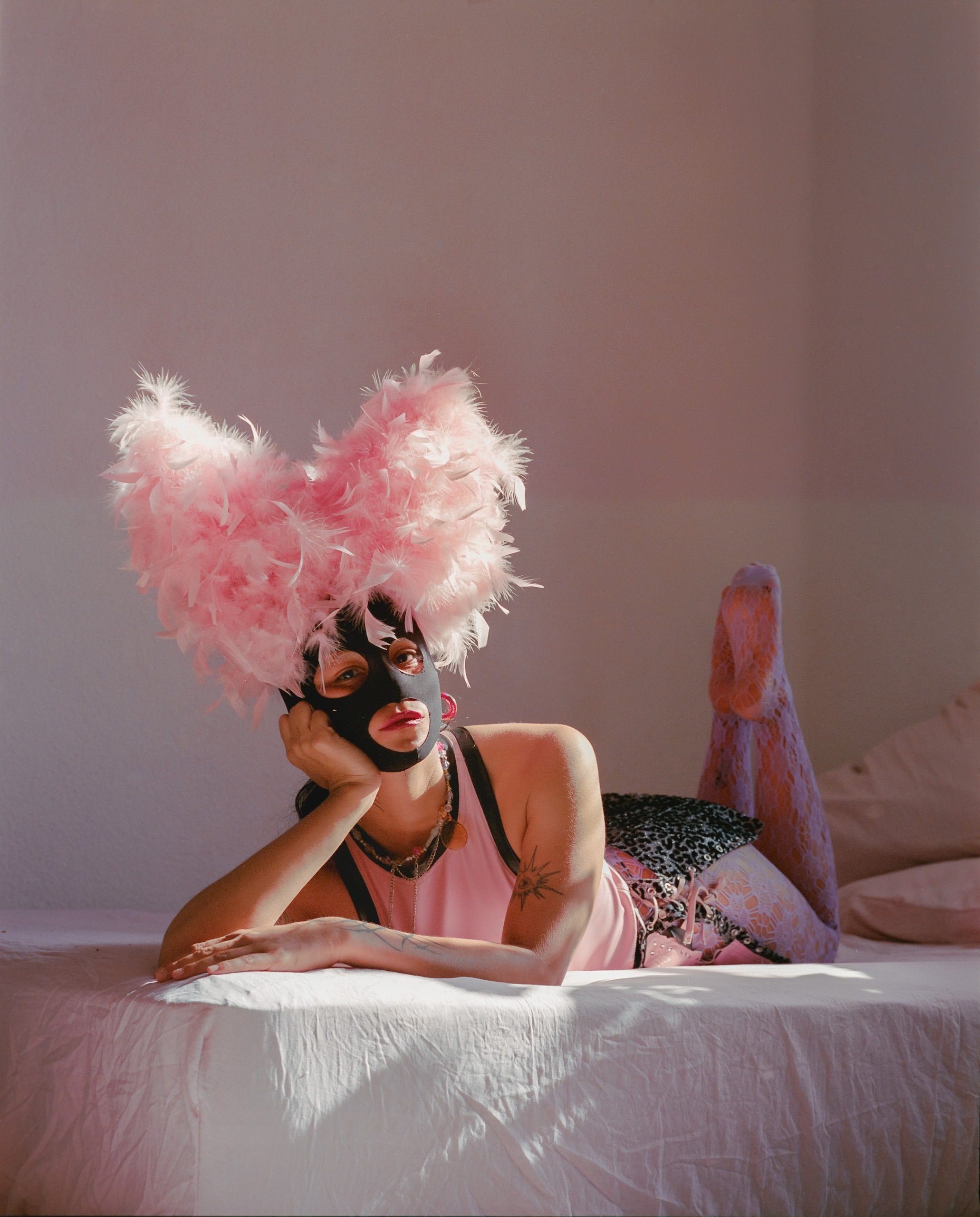 a-caged-dog-barks-the-fiercest-mexico-city-2024-performer-pink-feather-headdress-ryan-otoole-collett.jpeg