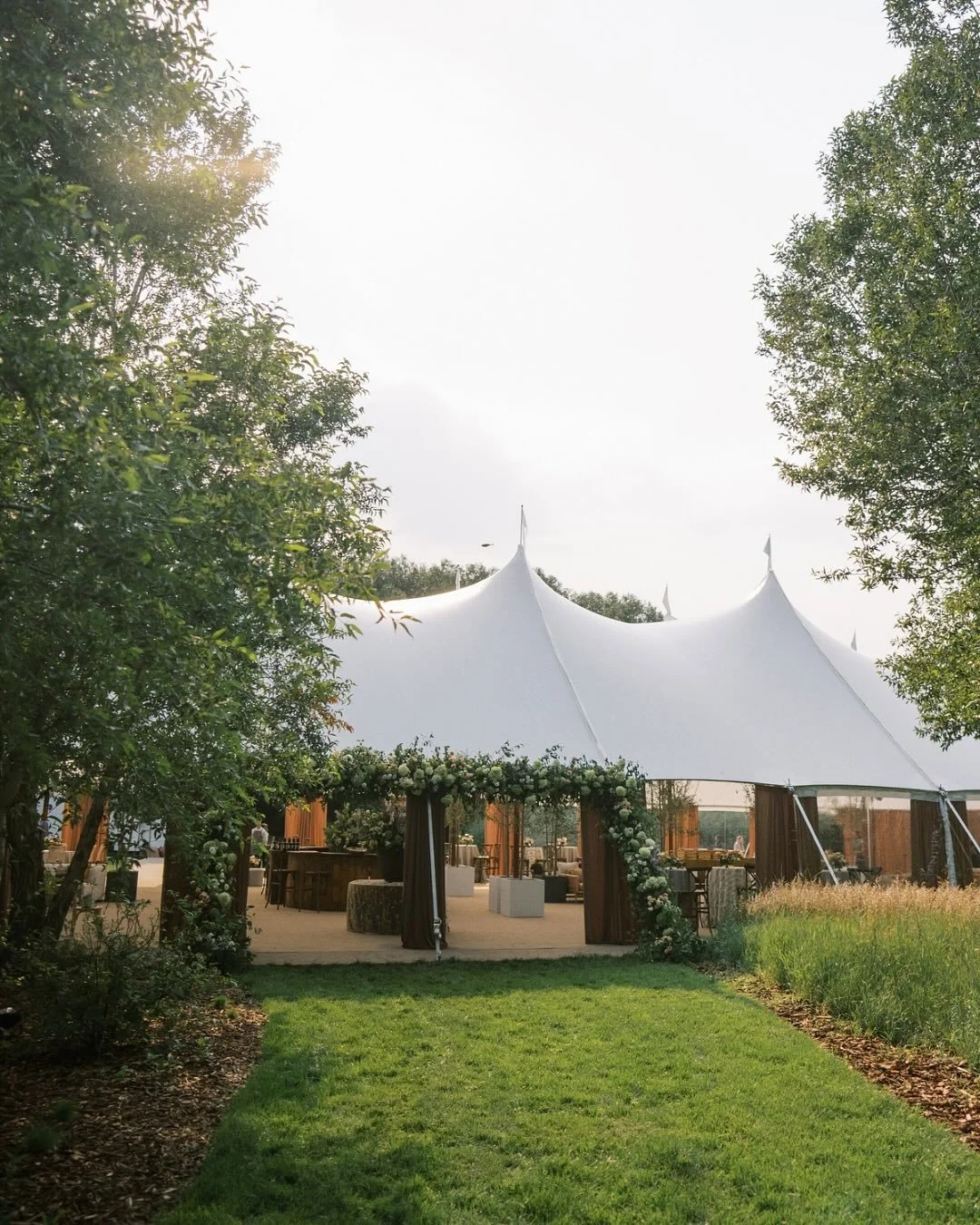 Mocha muse, but make it mountain-chic. 🤎

We brought the outside in (literally!) with live trees, natural textures, and a palette that warmed up the tent without competing with the view. Even the floor was custom, layered in tone to anchor the space