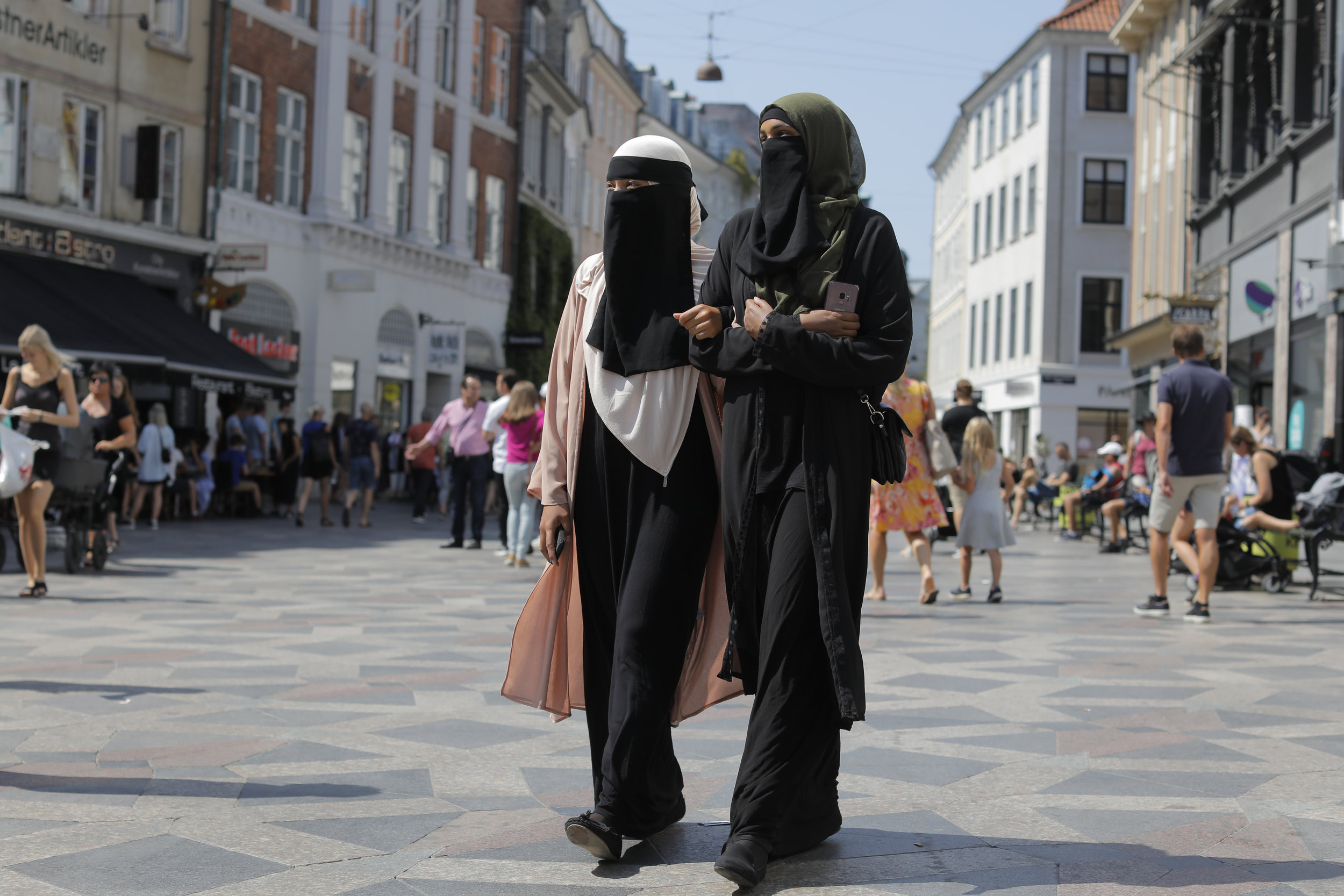 Anna-Bella and Amina clasp arms as they walk down Strøget, the main shopping street of Copenhagen. Their appearance often attracts a lot of attention.  Some people offering them words of support while others will yell offensive comments about their 