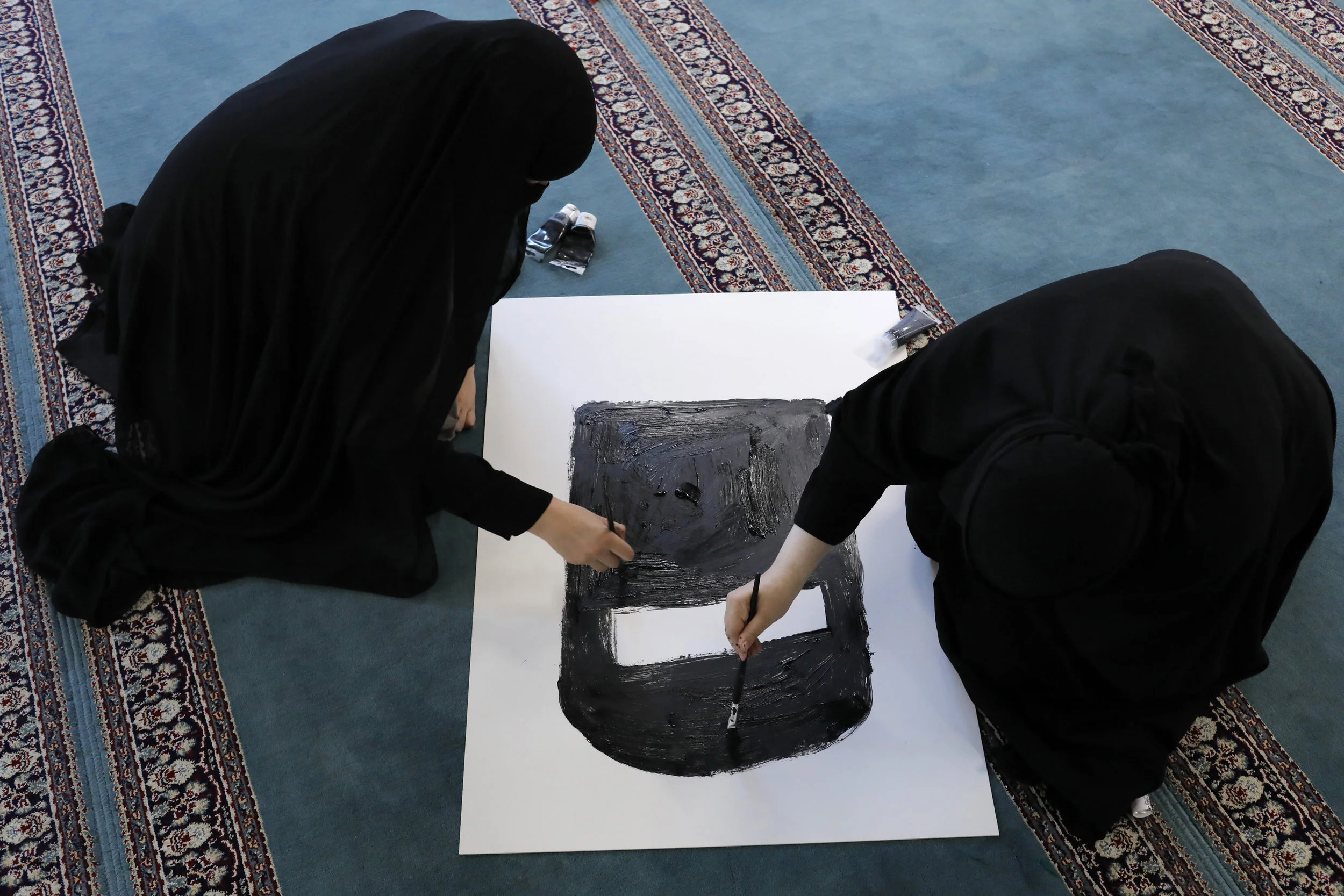  Alaa and Aisha paint a sign depicting a niqab during a workshop to prepare for the protest. The workshop was held following afternoon prayers in a mosque in Copenhagen’s north.  
