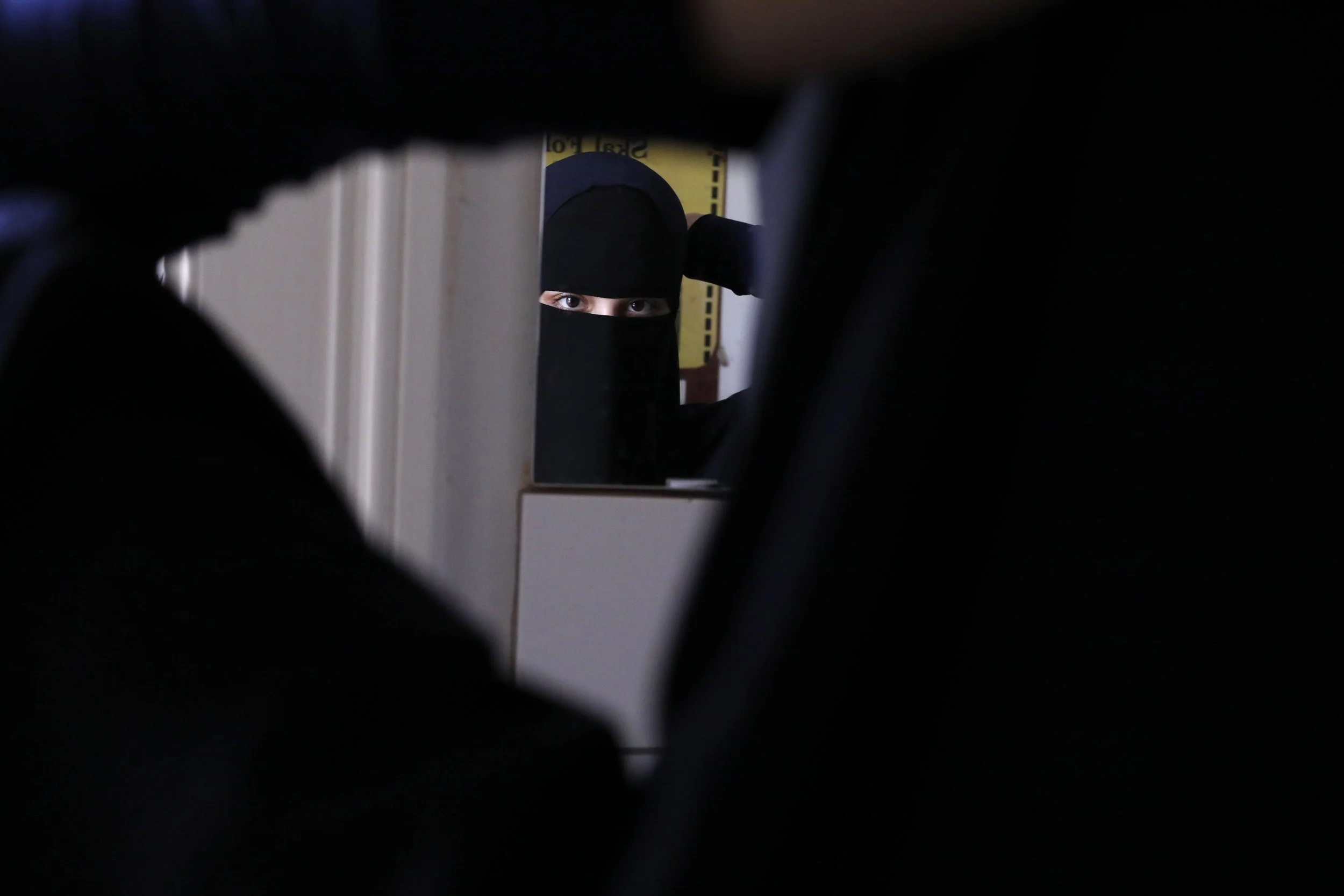  Alaa, 22, secures her niqab before leaving a meeting. She has worn a niqab since the age of 16 and has the blessing of her college to wear it to her classes. 