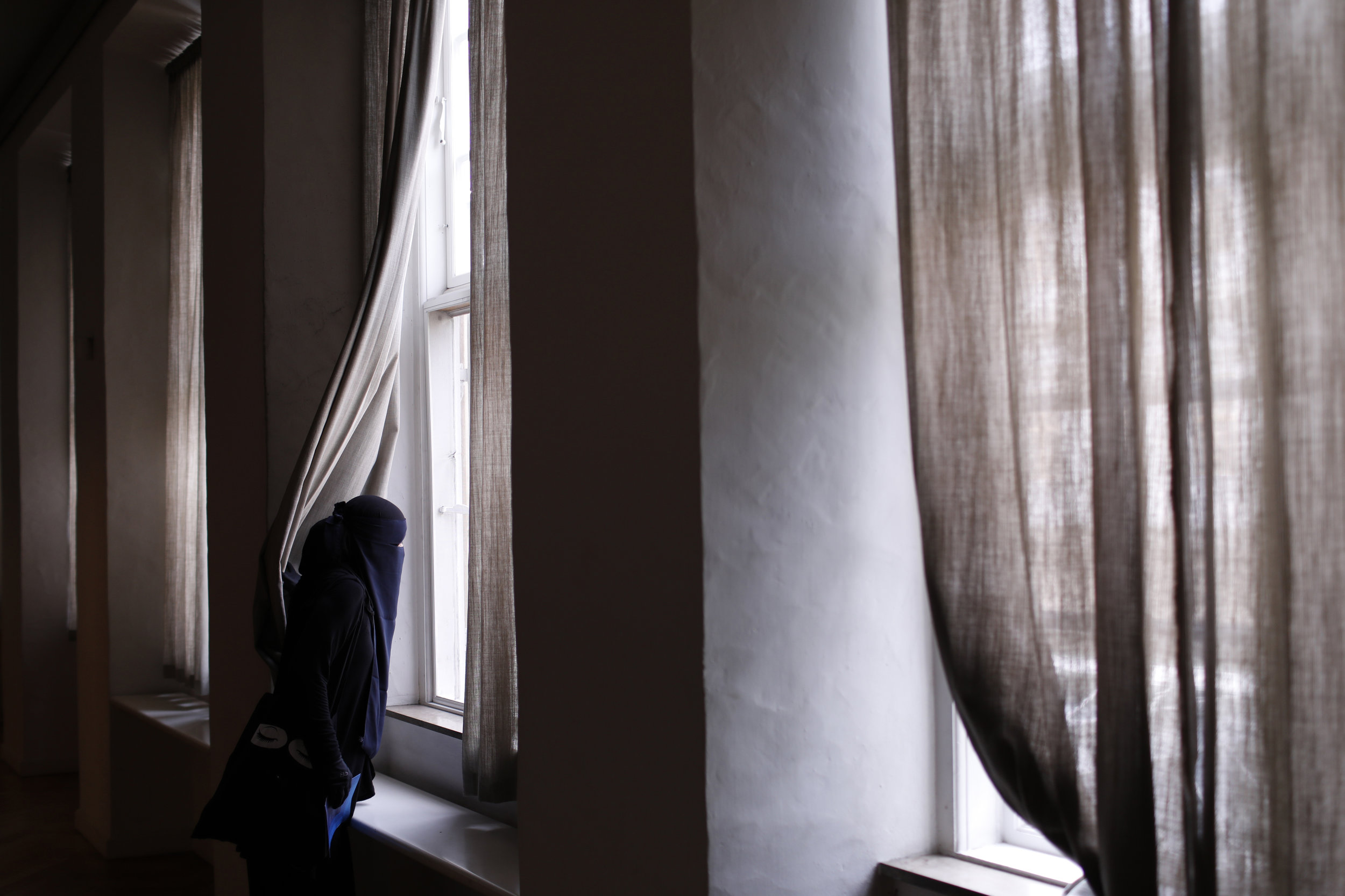  Ayah peers from a window in the National Museum of Denmark. It was a place she said she would miss most when the ban on wearing face veils in public came into effect. 