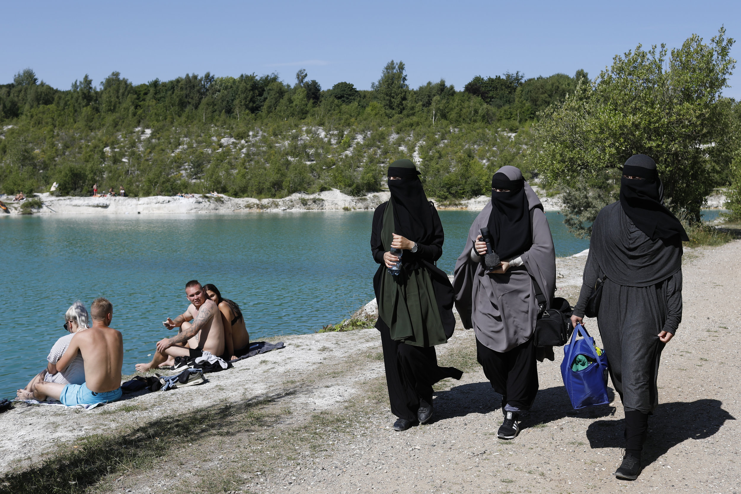  Swimmers watch on as women in niqabs walk by at a former chalk mine turned swimming hole outside of Copenhagen. A number of politicians often argue that by wearing niqabs, women contribute to what is often mentioned in the media as a parallel societ