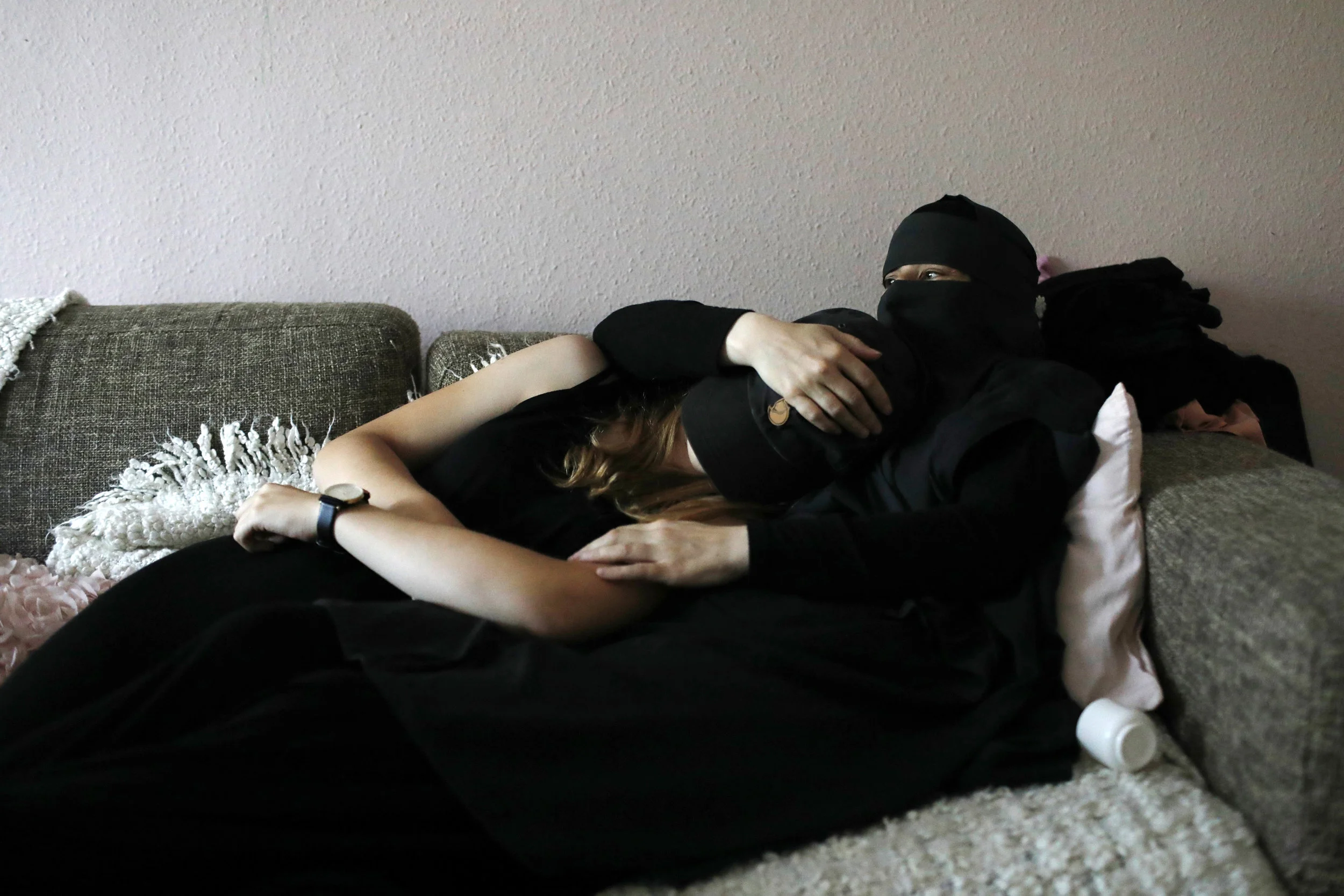  Ayah rests with her daughter in the apartment of a friend in Copenhagen. Her daughter does not practice the Islamic faith but is fully supportive of her mother to do so. 