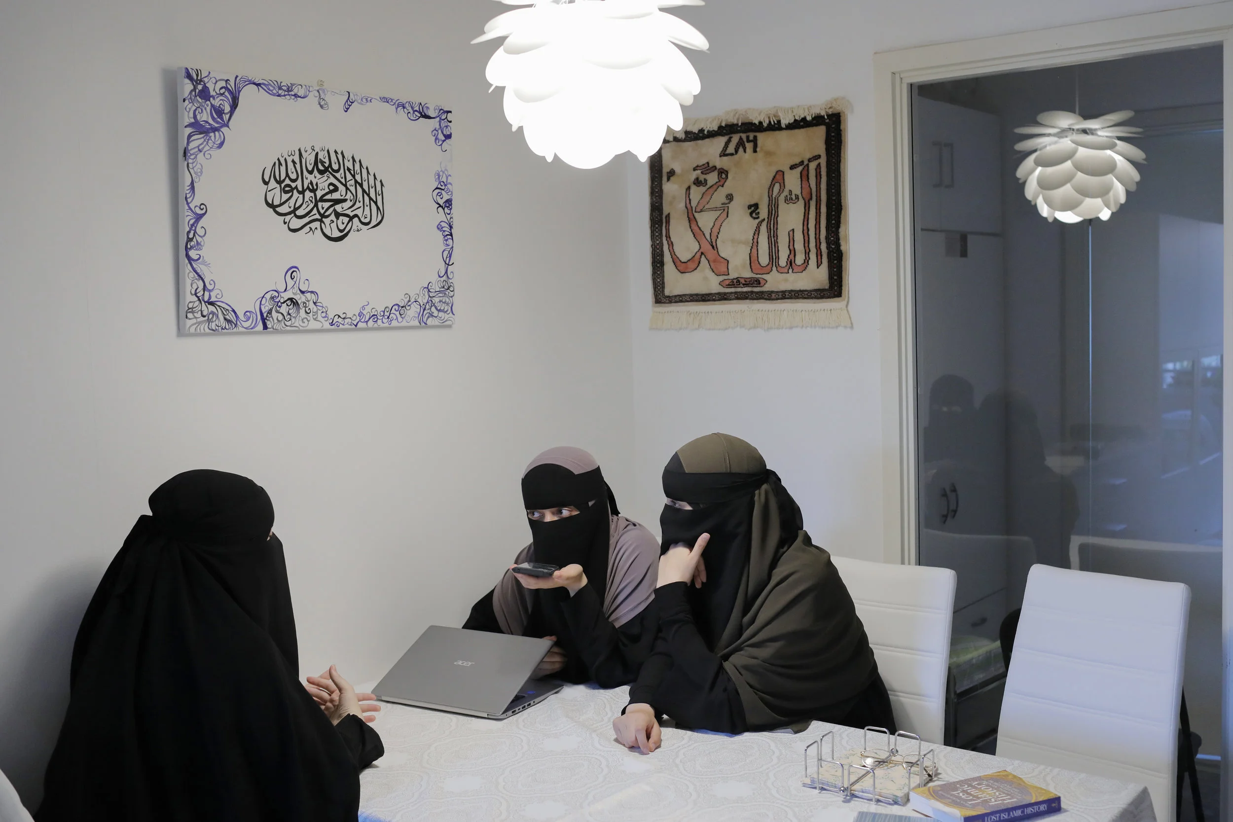  Aisha, Sabina and Alaa speak with Meryem on the phone to organize media interviews. All four are members of Women in Dialogue and were busy creating awareness of their plight in the lead-up to the ban. 