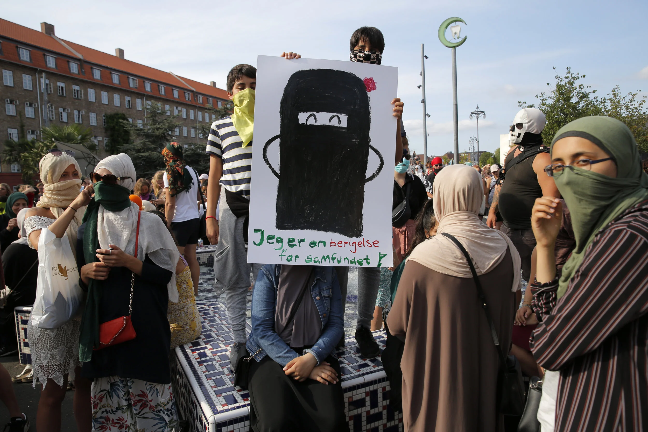  People gather at a protest held in Copenhagen on August 1, the day that the Danish veil ban came into effect. Many attendees covered their faces to support the niqab wearers and to protest the new law. 