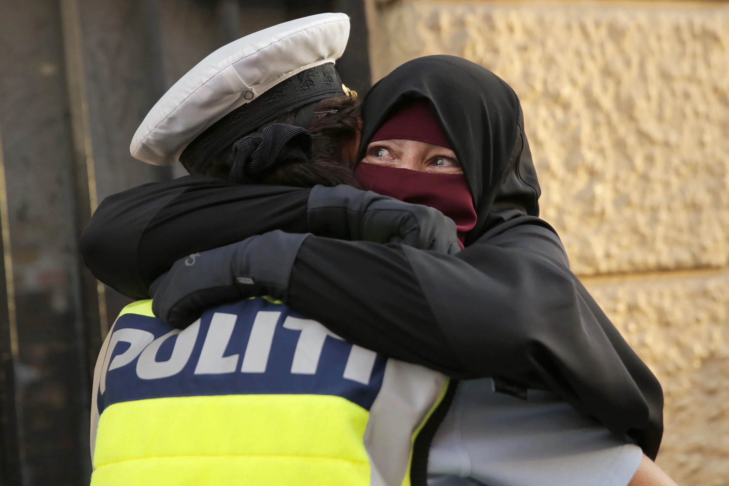  Ayah is embraced by a police officer during a protest against the veil ban in Copenhagen on August 1. The officer has since been subjected to investigations ordered by the ruling political party of Denmark for “appearing to take sides on the issue.”
