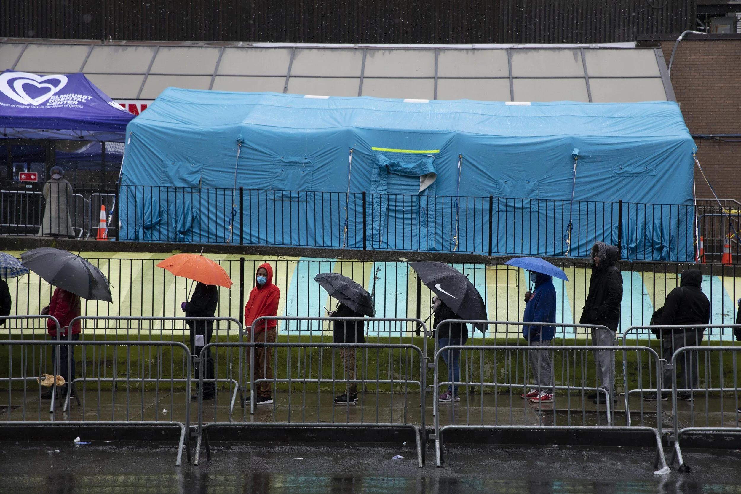  People queue outside a tent erected to conduct testing for coronavirus at the Elmhurst Hospital in Queens. Some day saw hundreds of people arrive for testing, standing in line for several hours, in this case during a rain storm.  