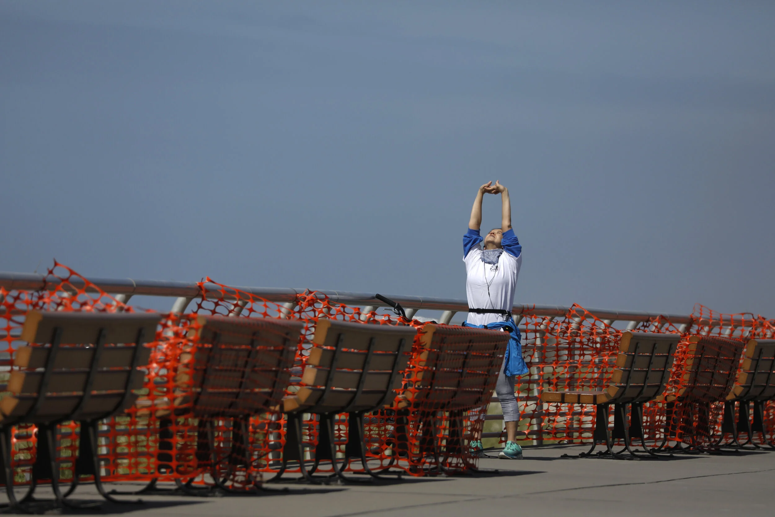  An early morning exerciser stretches amongst benches covered to promote social distancing along the boardwalk at Long Beach on Long Island. Beaches in the region opened ahead of the Memorial Day weekend with precautions in place to prevent the sprea