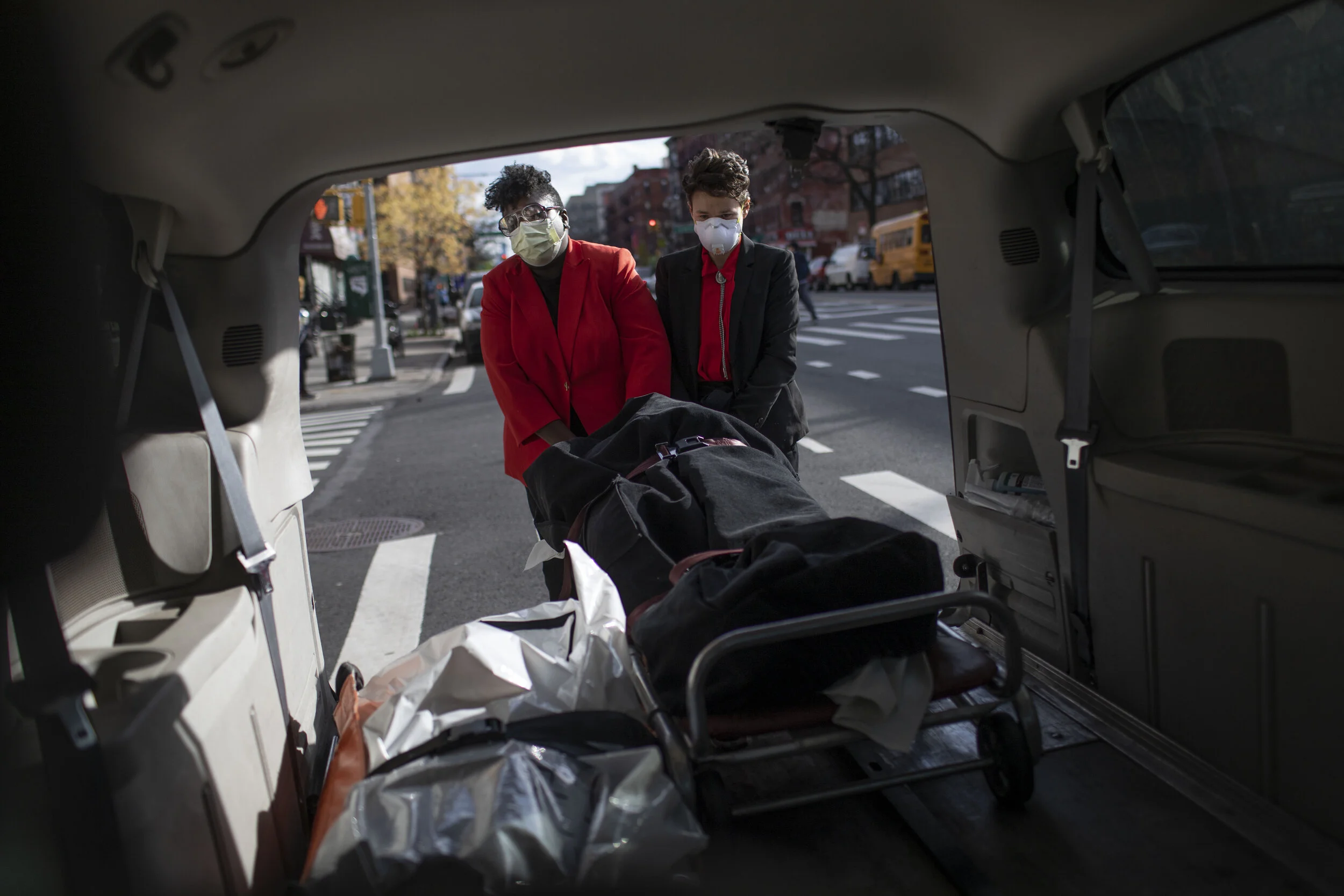  Nicole Warring and Lily Sage Weinrieb pull a body from the funeral home’s van while parked on Amsterdam Avenue in Harlem.  
