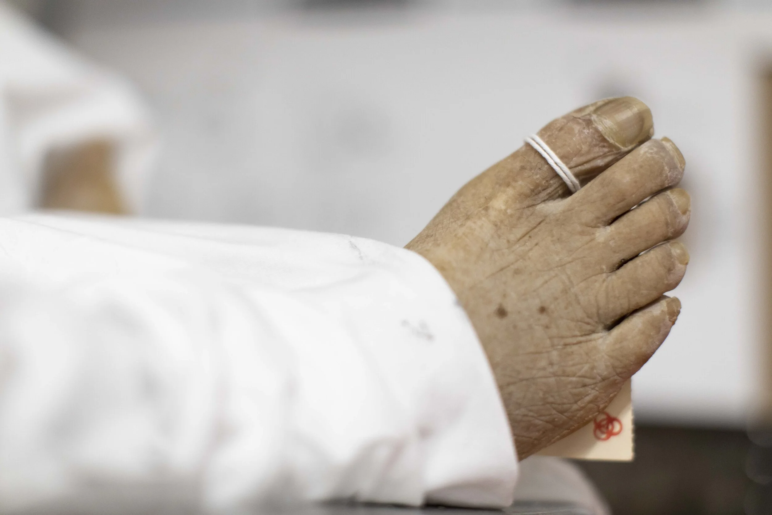  A biohazard toe tag is seen on a body in the basement.  