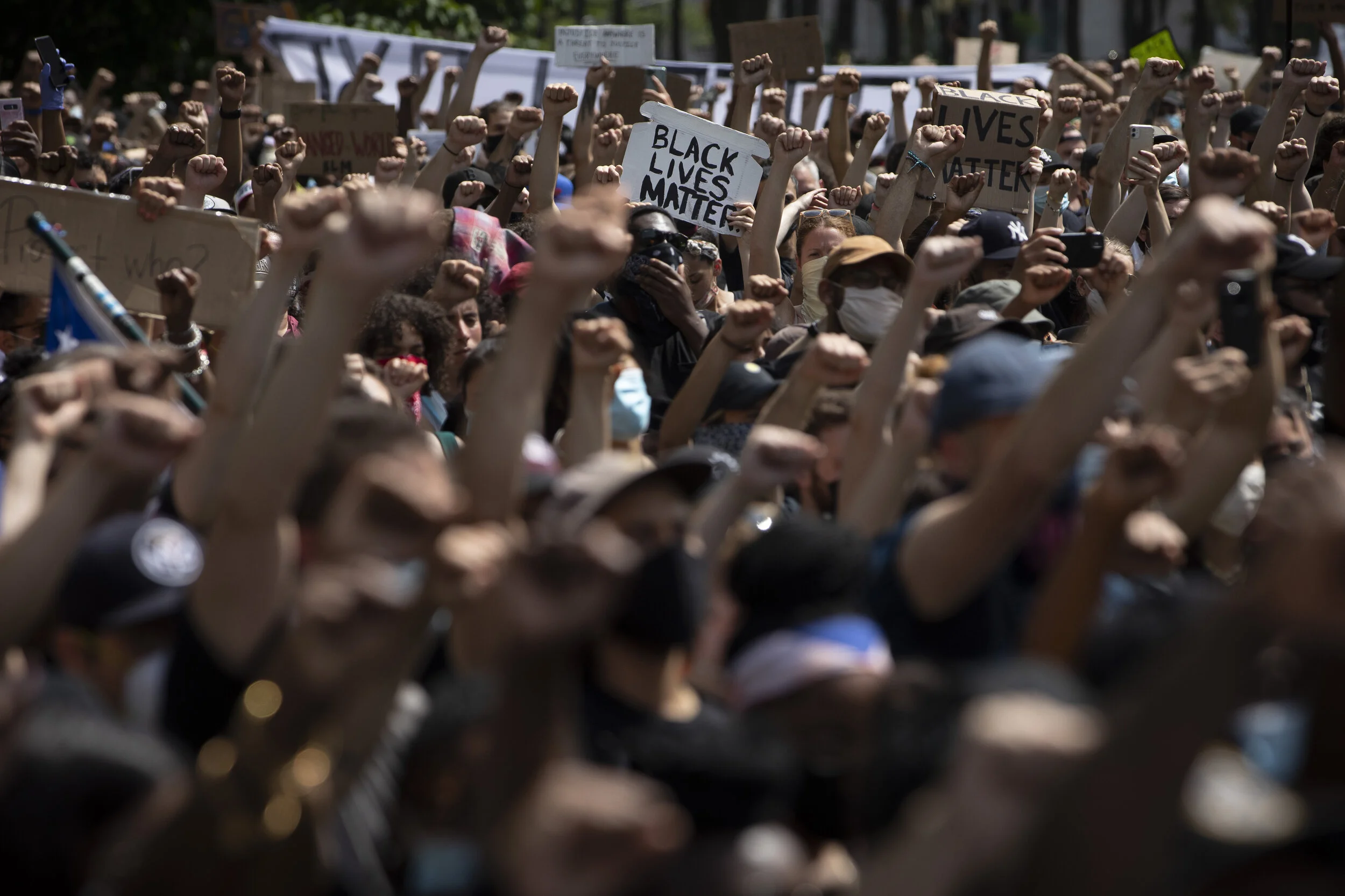  Protesters raise their fist during a moment of silence during a gathering at Cadman Plaza in Brooklyn.  
