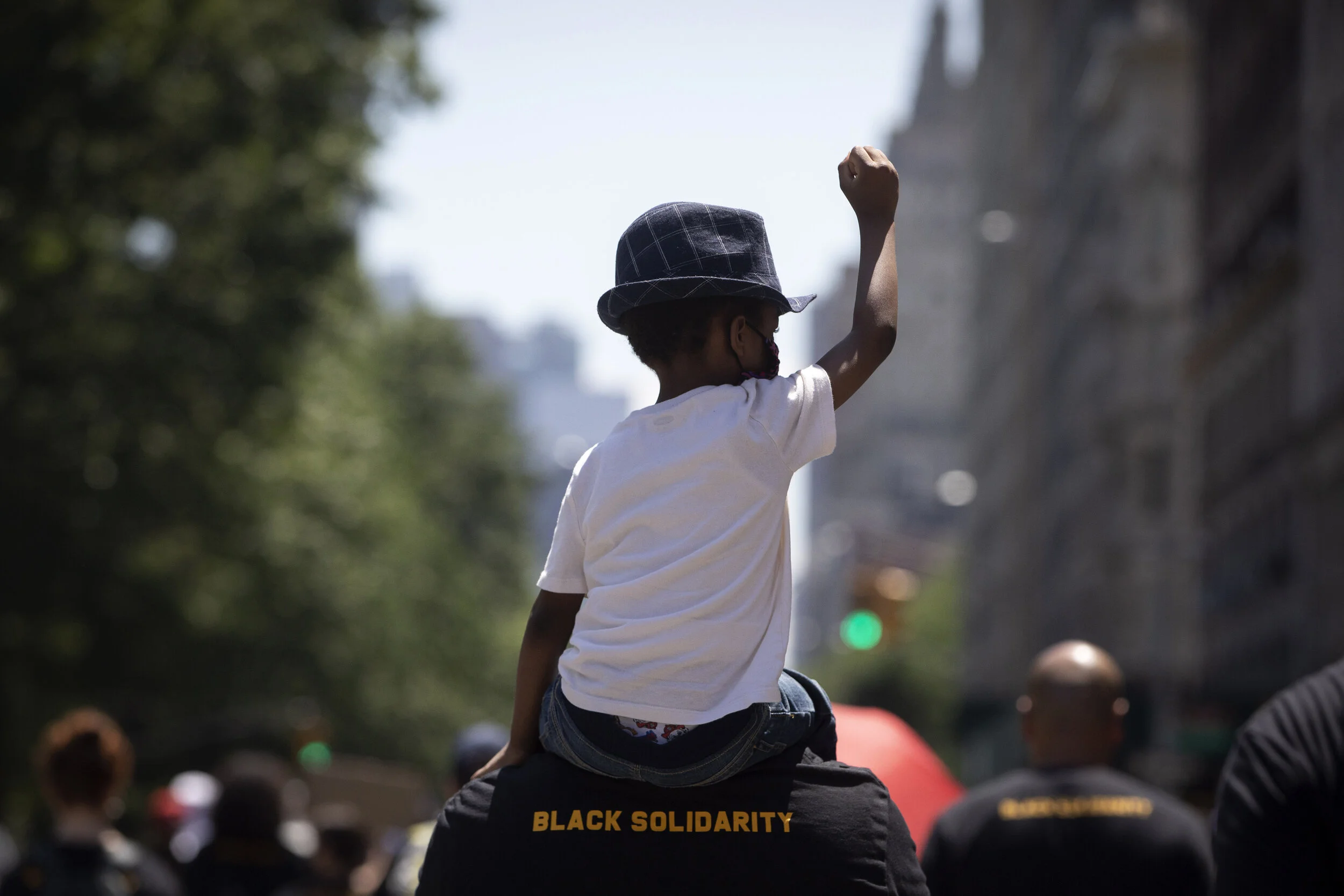  A child raises his fist as he is carried during a protest down Central Park West in Manhattan to commemorate Juneteenth.  