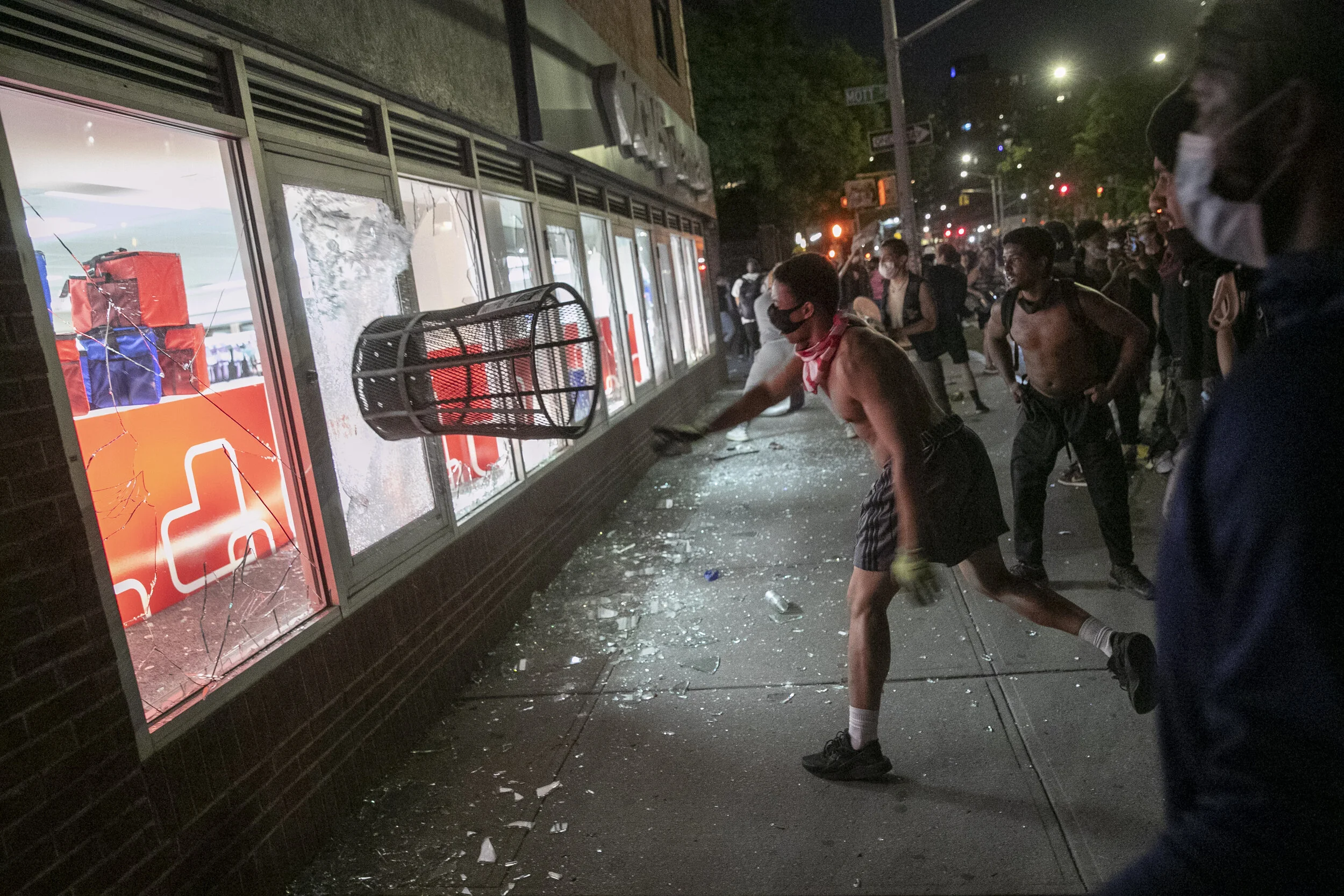  Protesters throw a trashcan through a store window during a protest in Manhattan.  