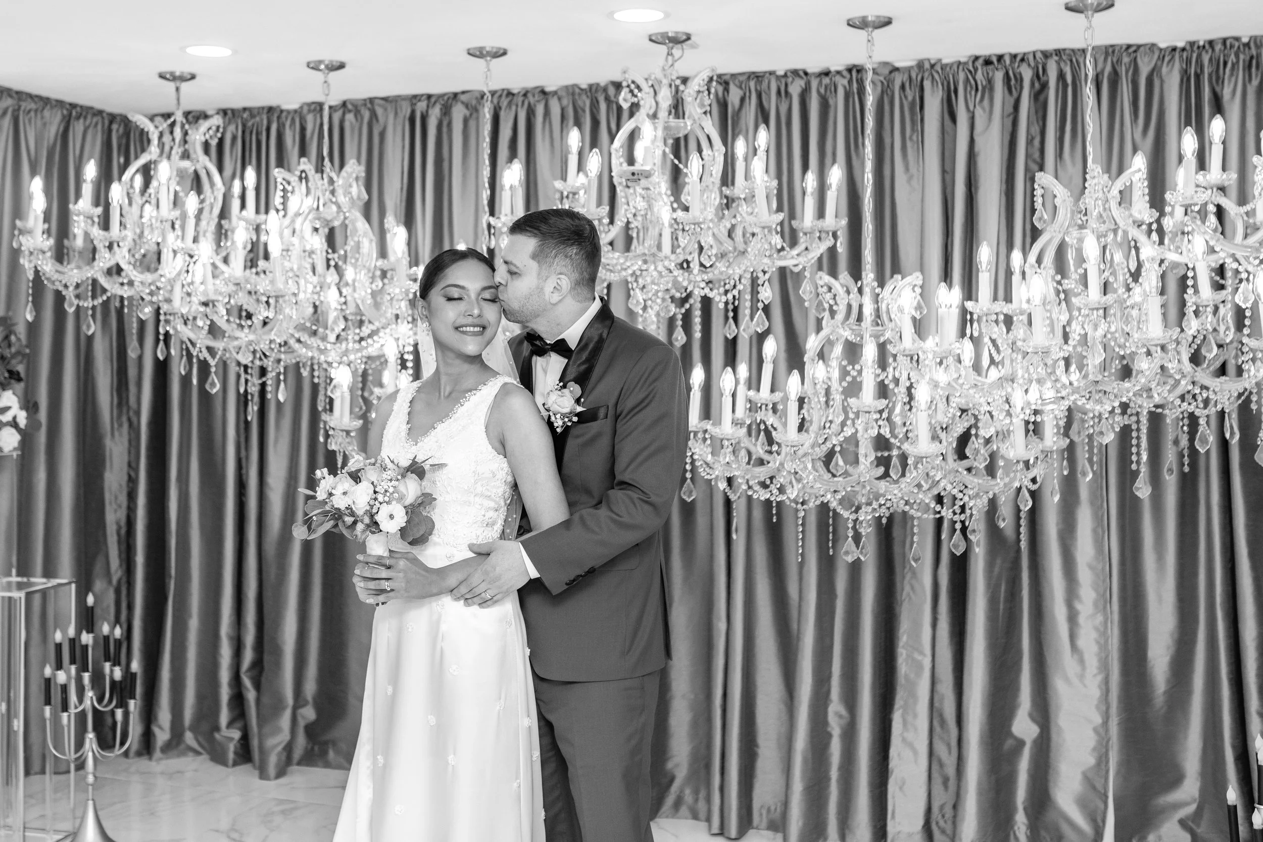 Beautiful couple embraces in front of cascading crystal chandeliers in Las Vegas Wedding Chapel Love Story Chandelier Chapel