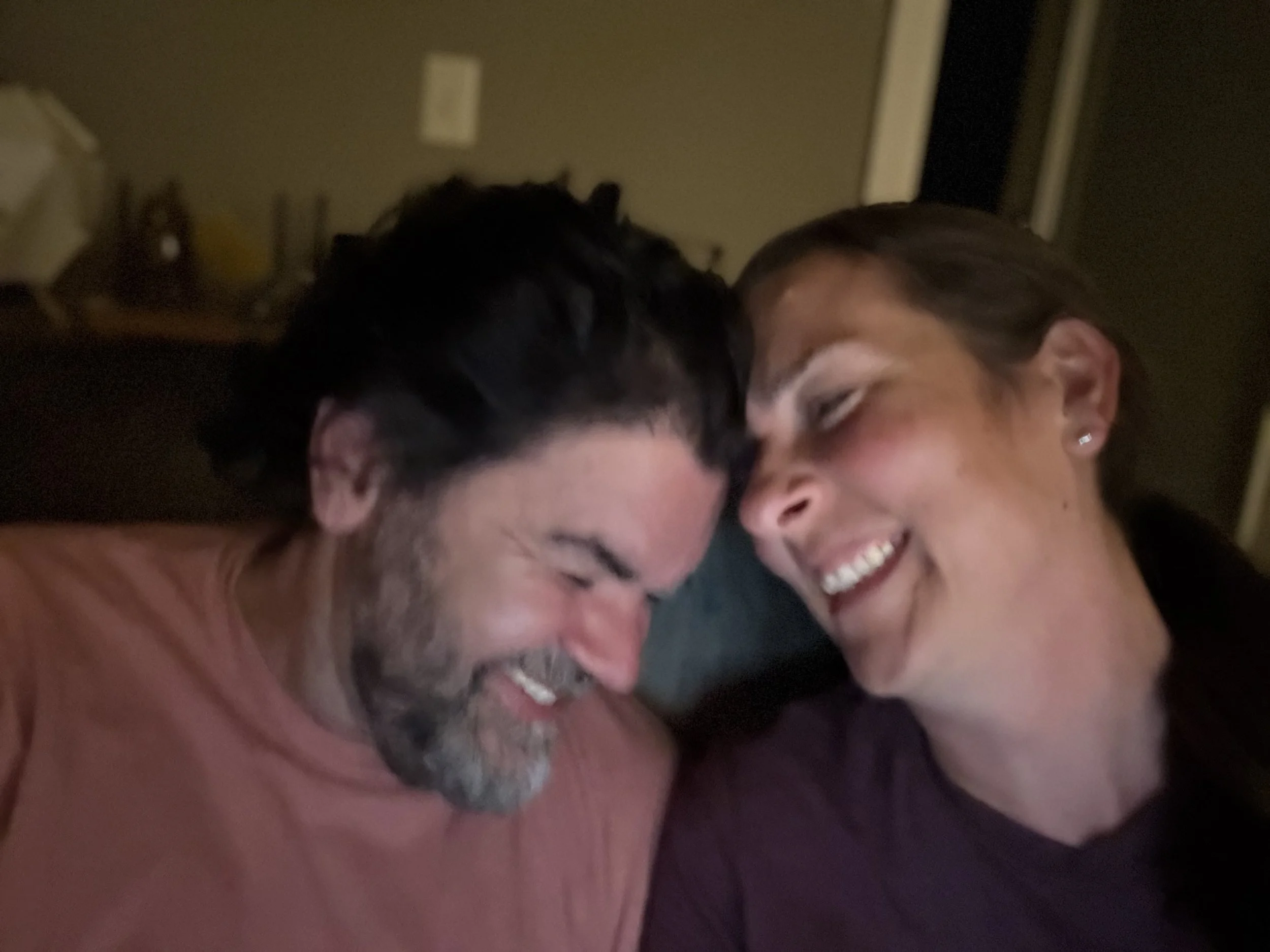Nick Bergus and Laura Bergus laugh while trying to take a selfie.