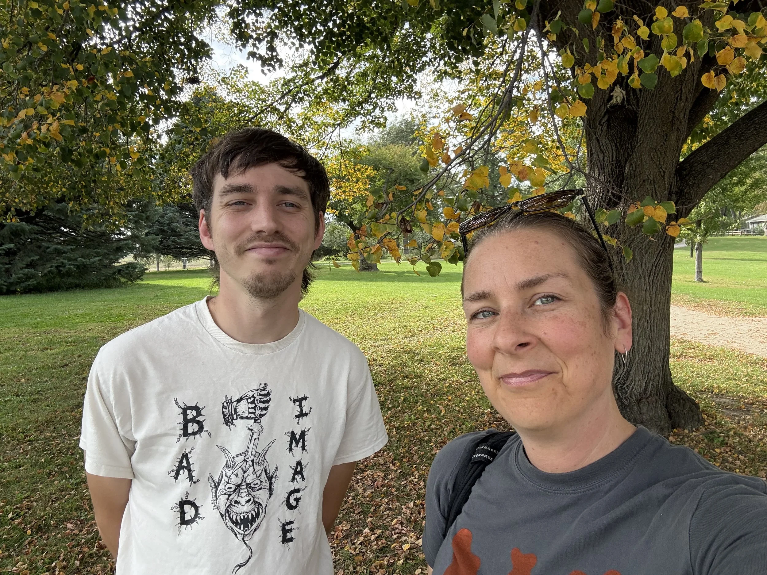 Oliver Weilein and Laura Bergus pose in front of fall foliage at Iowa City's Wetherby Park.