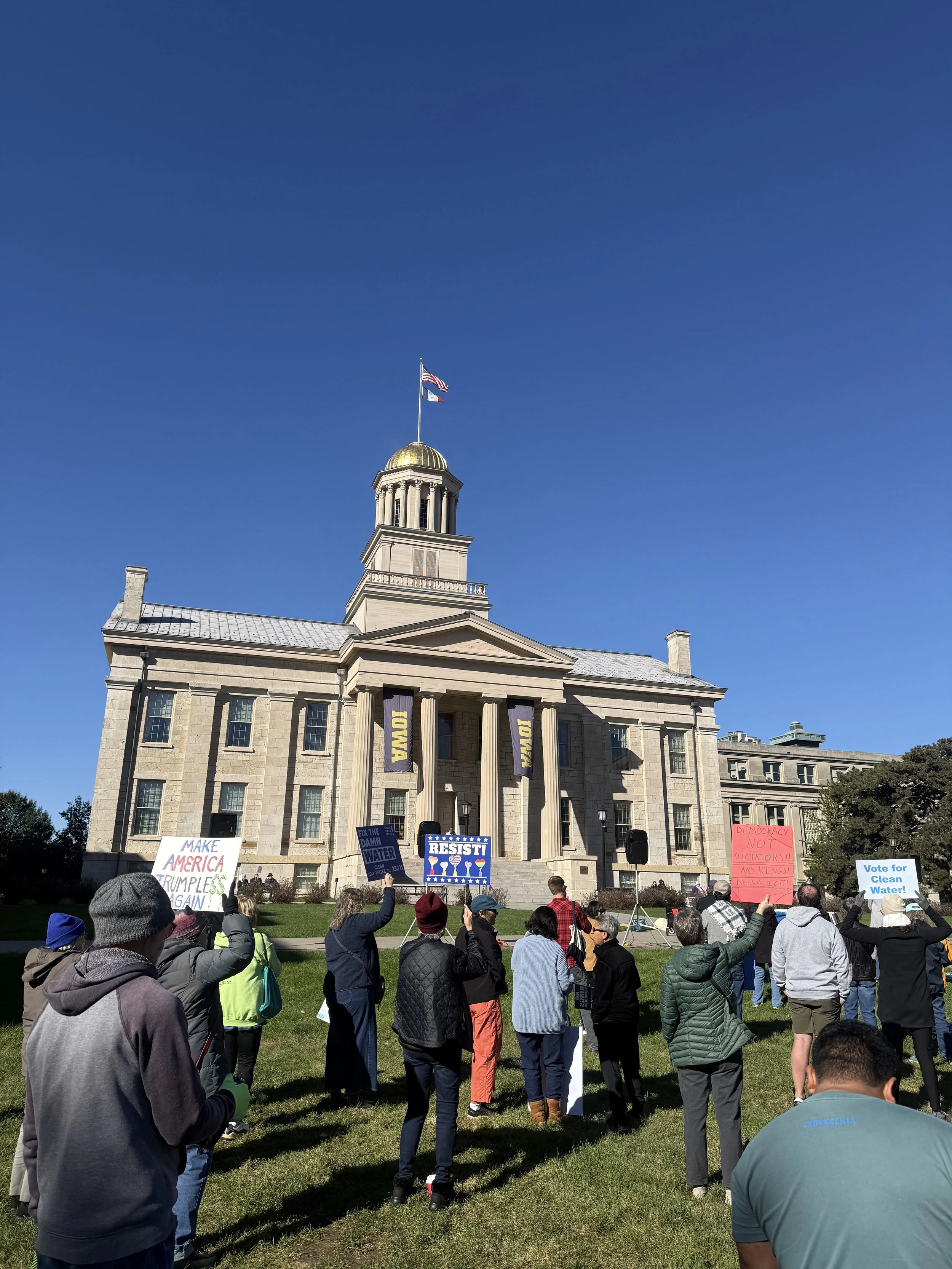 People rally in front of the historic Old Capitol in Iowa City on October 17, 2026, in support of the No Kings movement.