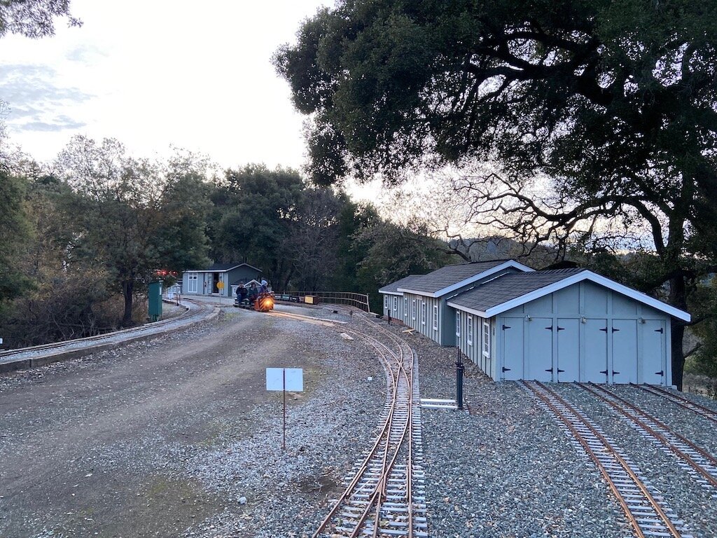  The speeder train heads crosses into the North Yard passing the Ron Schmidt Car Barn 