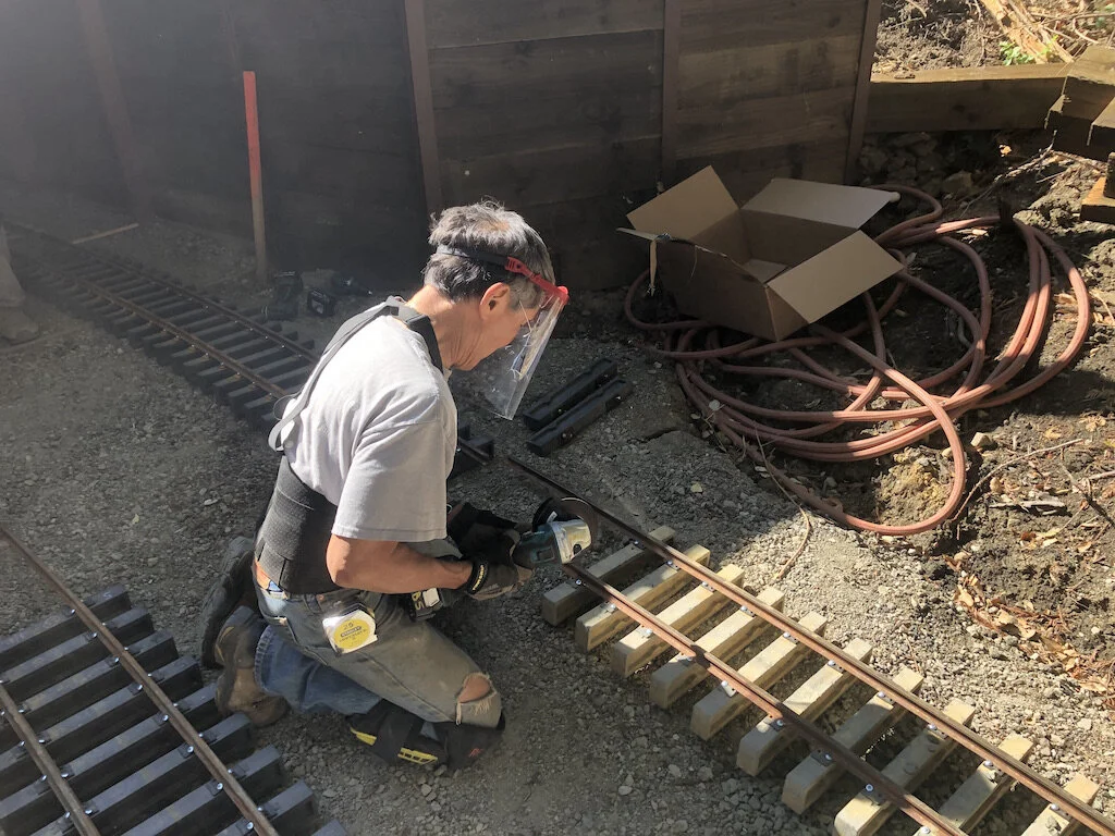 Cutting rail with a shield to avoid melting plastic eyeglass lenses