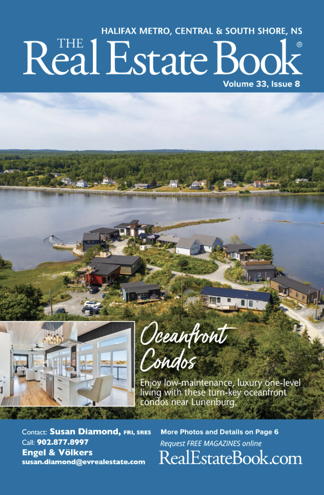 front cover of a real estate magazine with an arial shot of small, oceanfront homes on a cove.