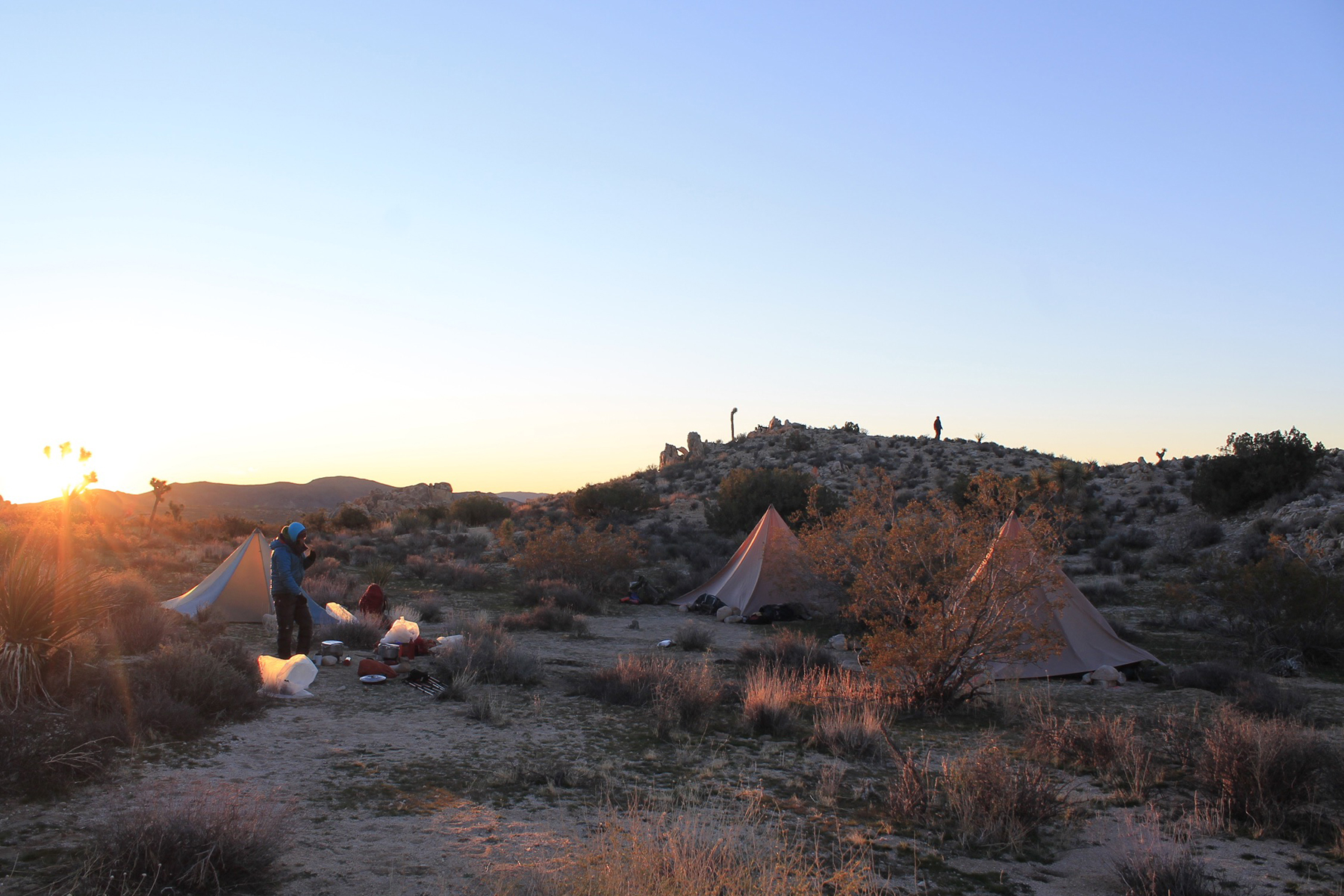 Outward Bound instructor passing by campsite during sunset.