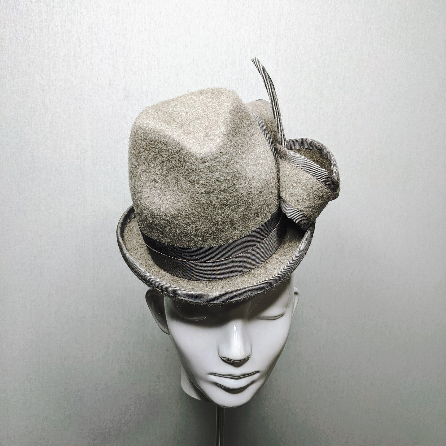 Meet Jessie, a 3/4 size Trilby with a turned up brim. The crown is also higher for a modern look, and wears like a fascinator. Its color is warm grey. Its material is wool angora. There is a special $100 discount for Jessie. Expires in a week. Use co