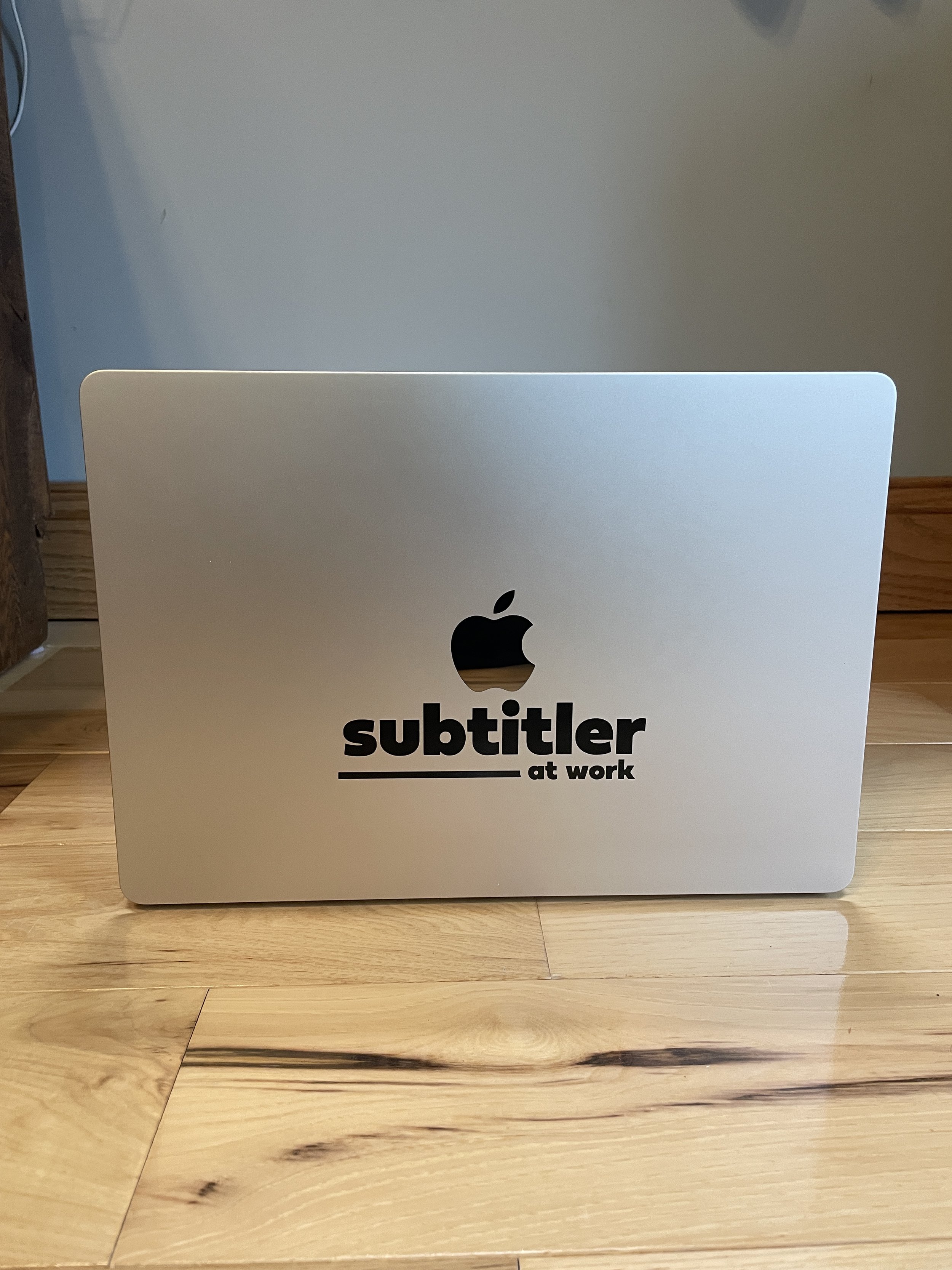 This is a photo of my laptop featuring the “subtitler at work” sticker.
