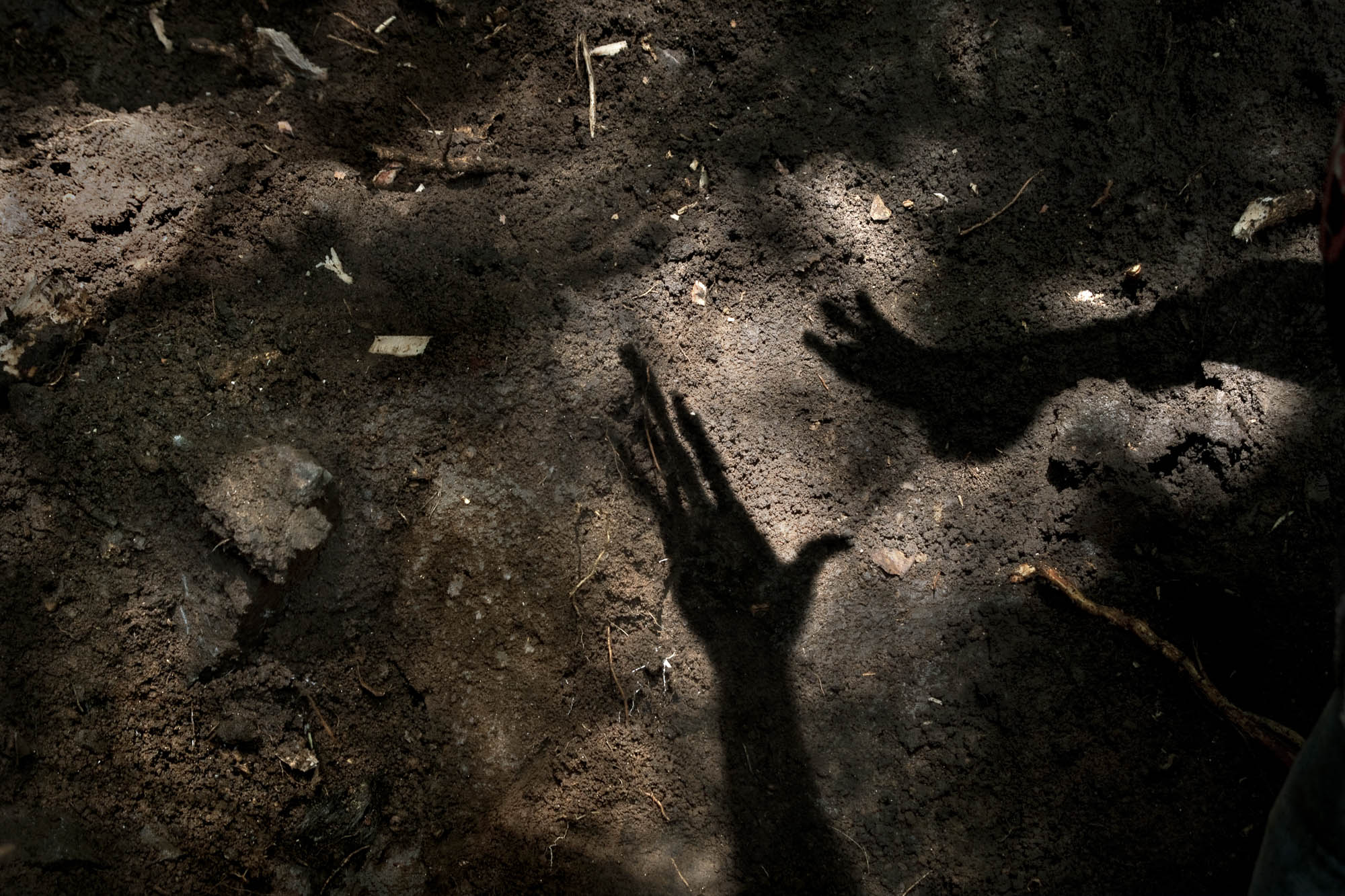  Israel projects his hands in the ground where he plans to dig searching for the body of William. 