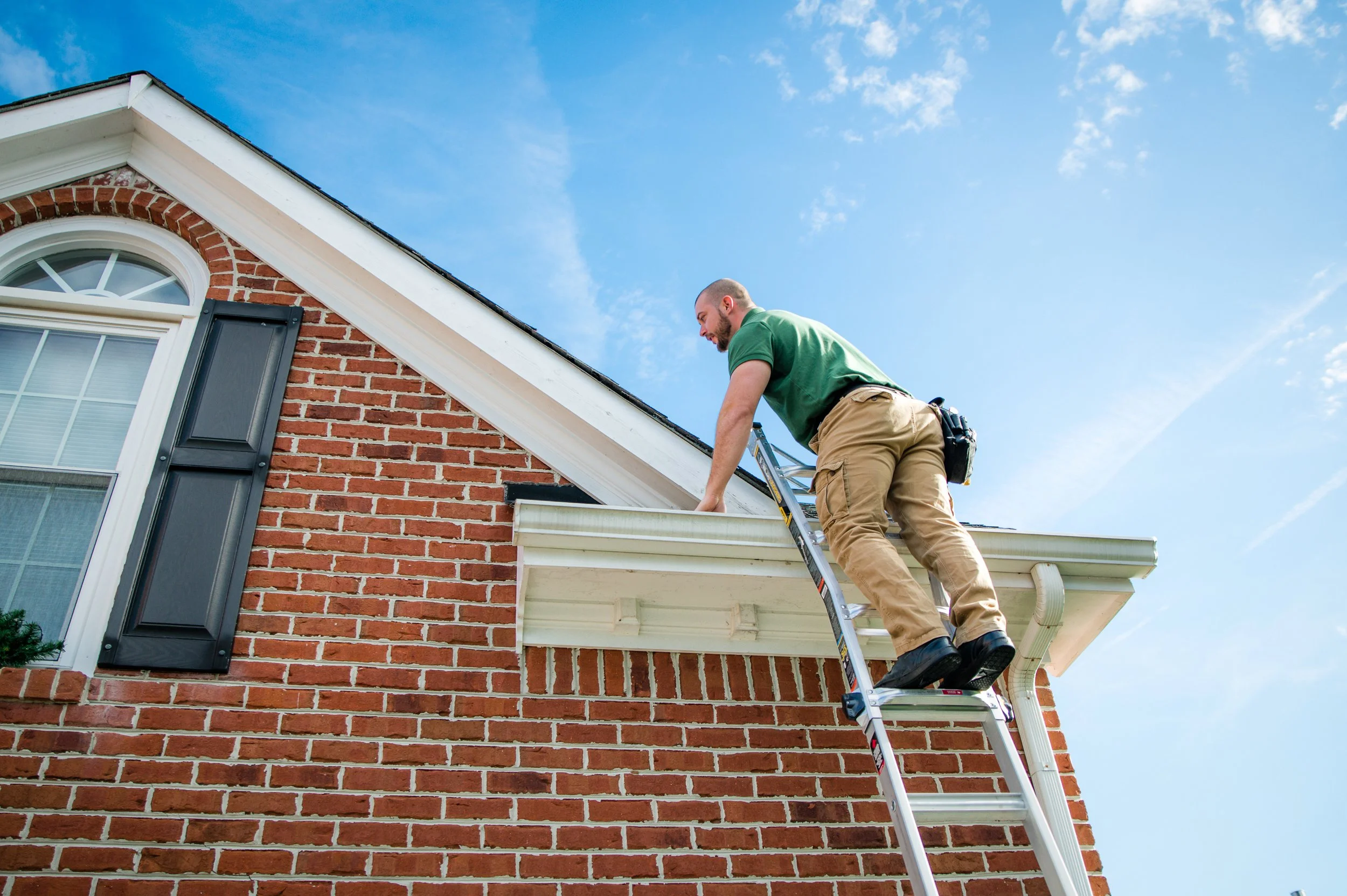 Jacob Knapp on a ladder inspecting a Virginia Beach home exterior and roofline.Jacob Knapp on a ladder inspecting a Virginia Beach home exterior and roofline.