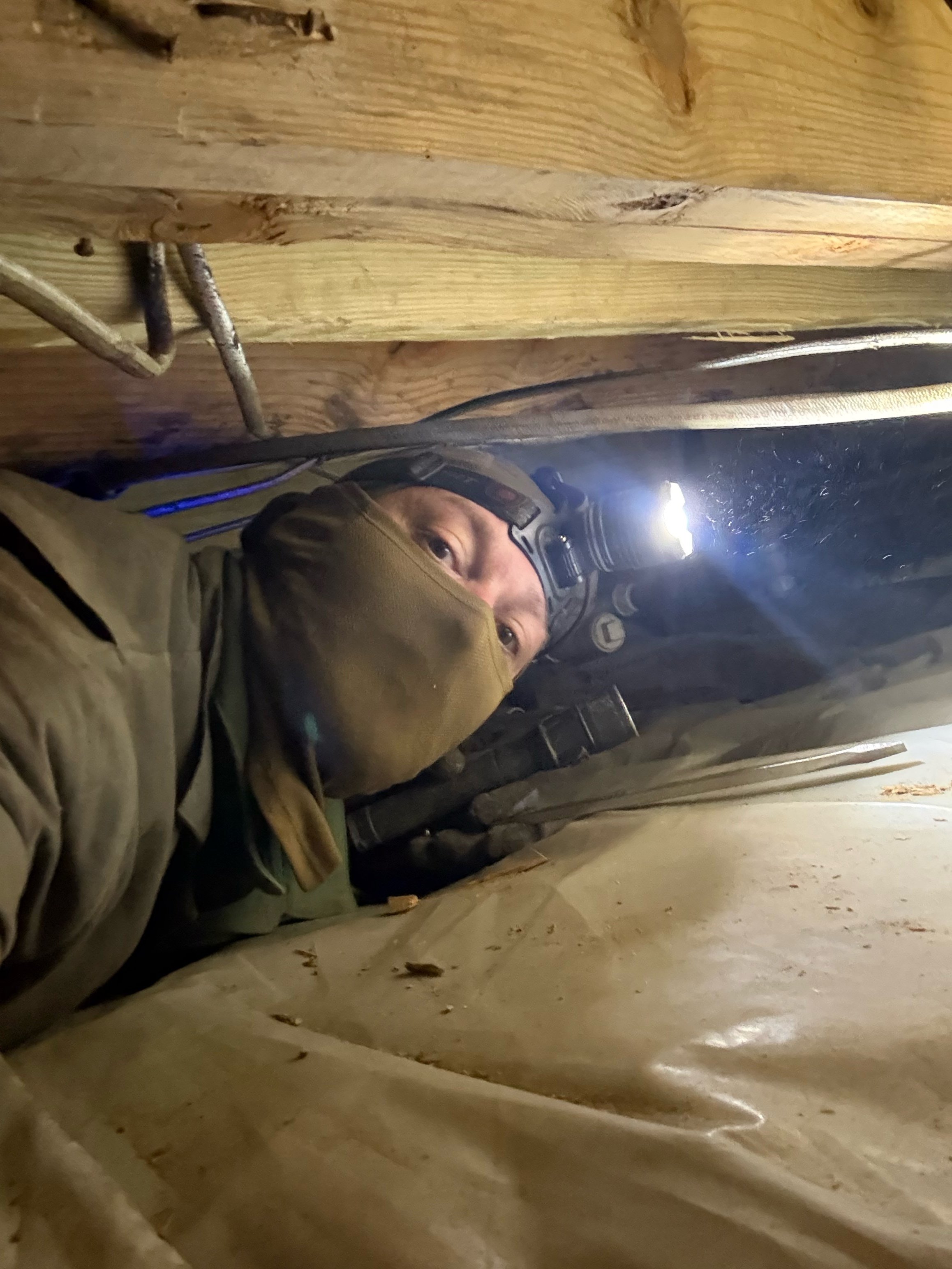 Jacob Knapp in a crawlspace under floor joists during a home inspection.Jacob Knapp in a crawlspace under floor joists during a home inspection.