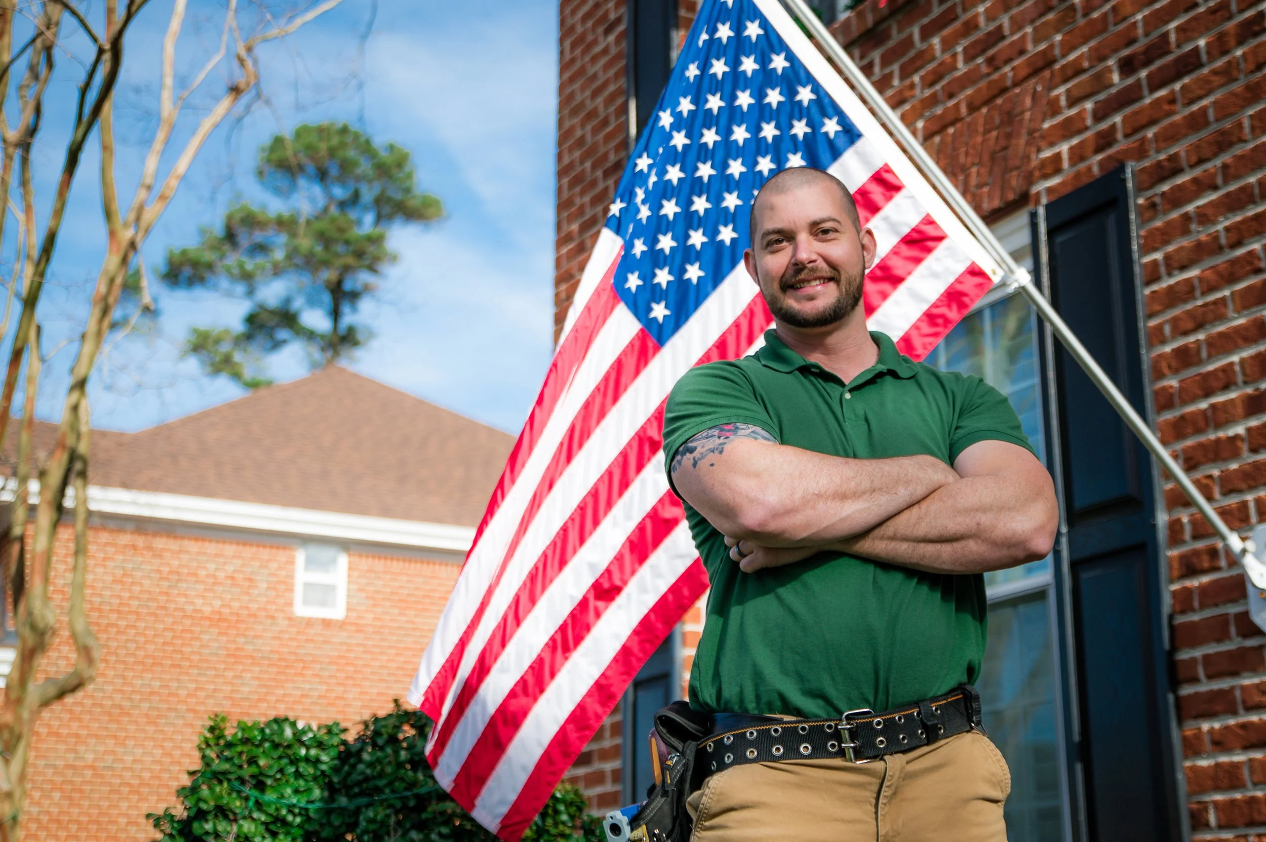 Jacob Knapp, veteran home inspector in Virginia Beach, in front of a brick home with an American flag.