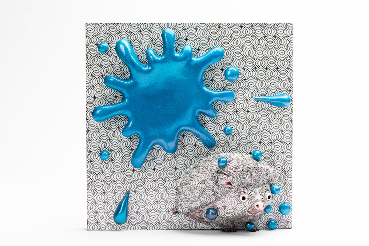 unique ceramic and mixed media sculpture by ceramicist Jennifer McCandless of hedgehog hiding in op art black and white pattern with blue splatters at Soapbox Arts Gallery